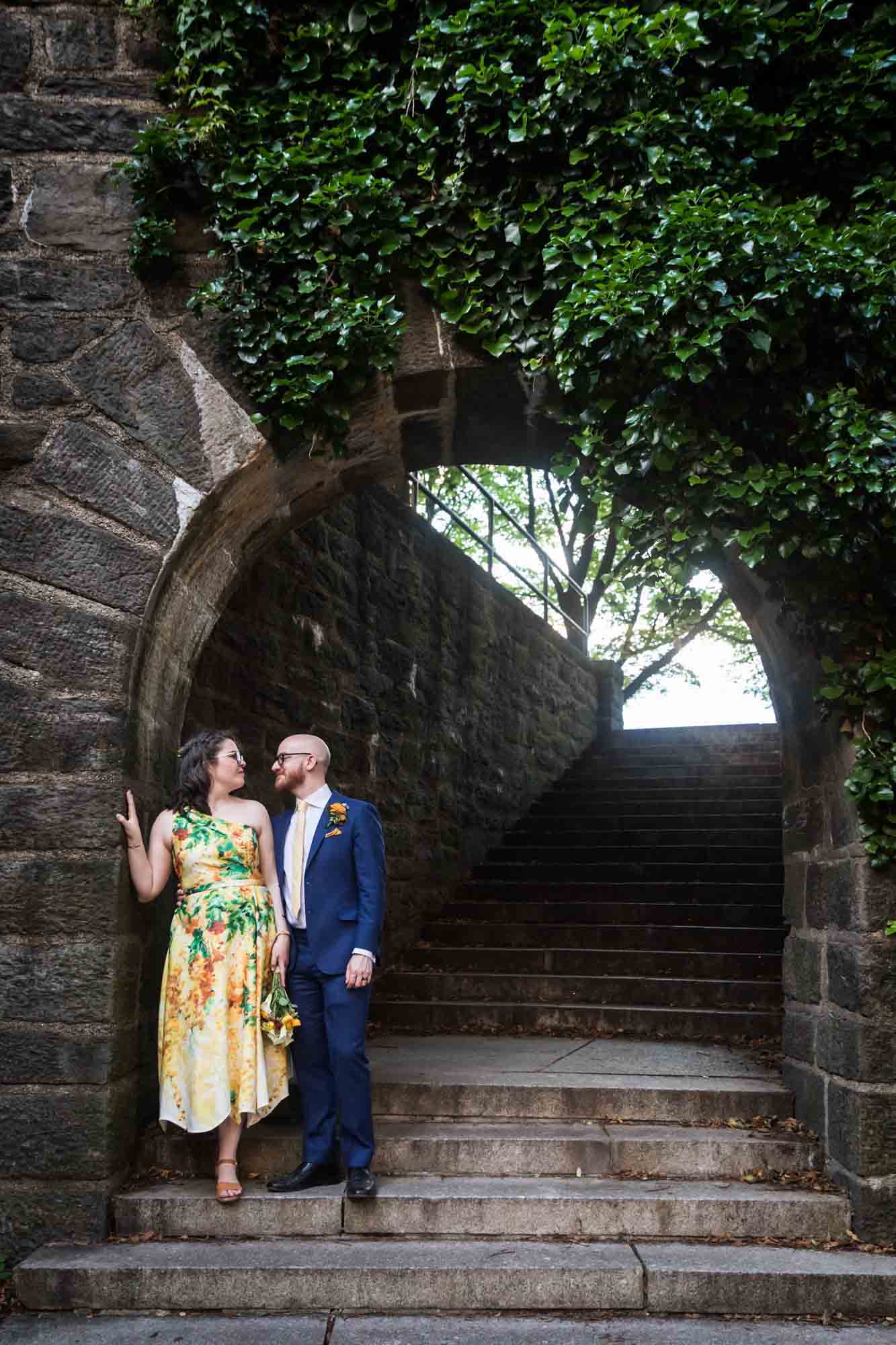 Fort Tryon wedding photos of bride and groom under stone archway in Linden Terrace