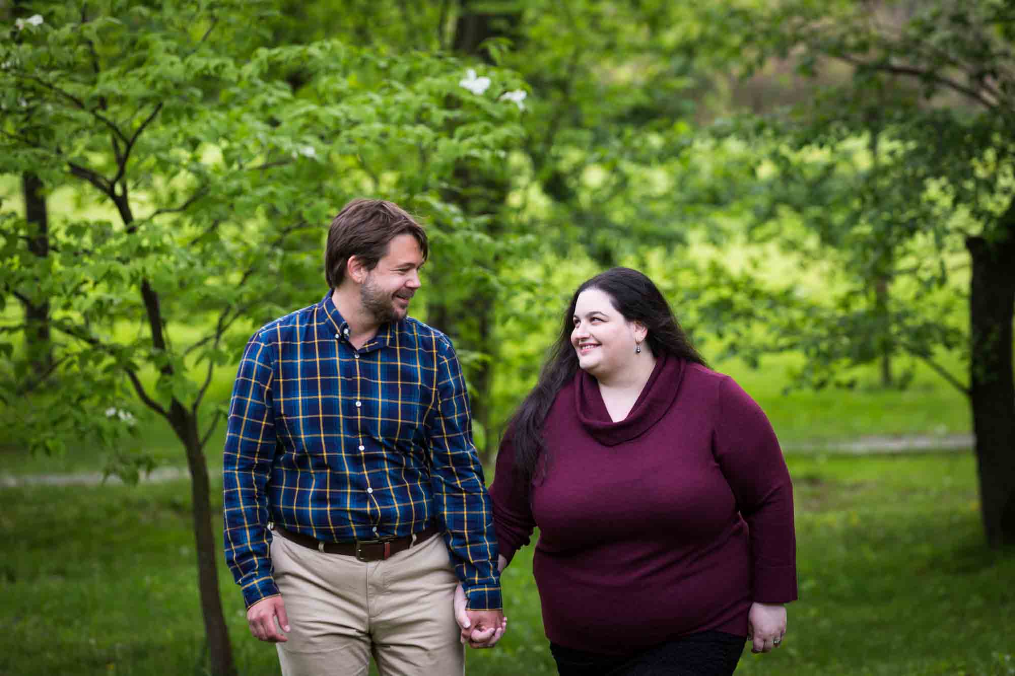 Snug Harbor engagement photos of couple holding hands in forest