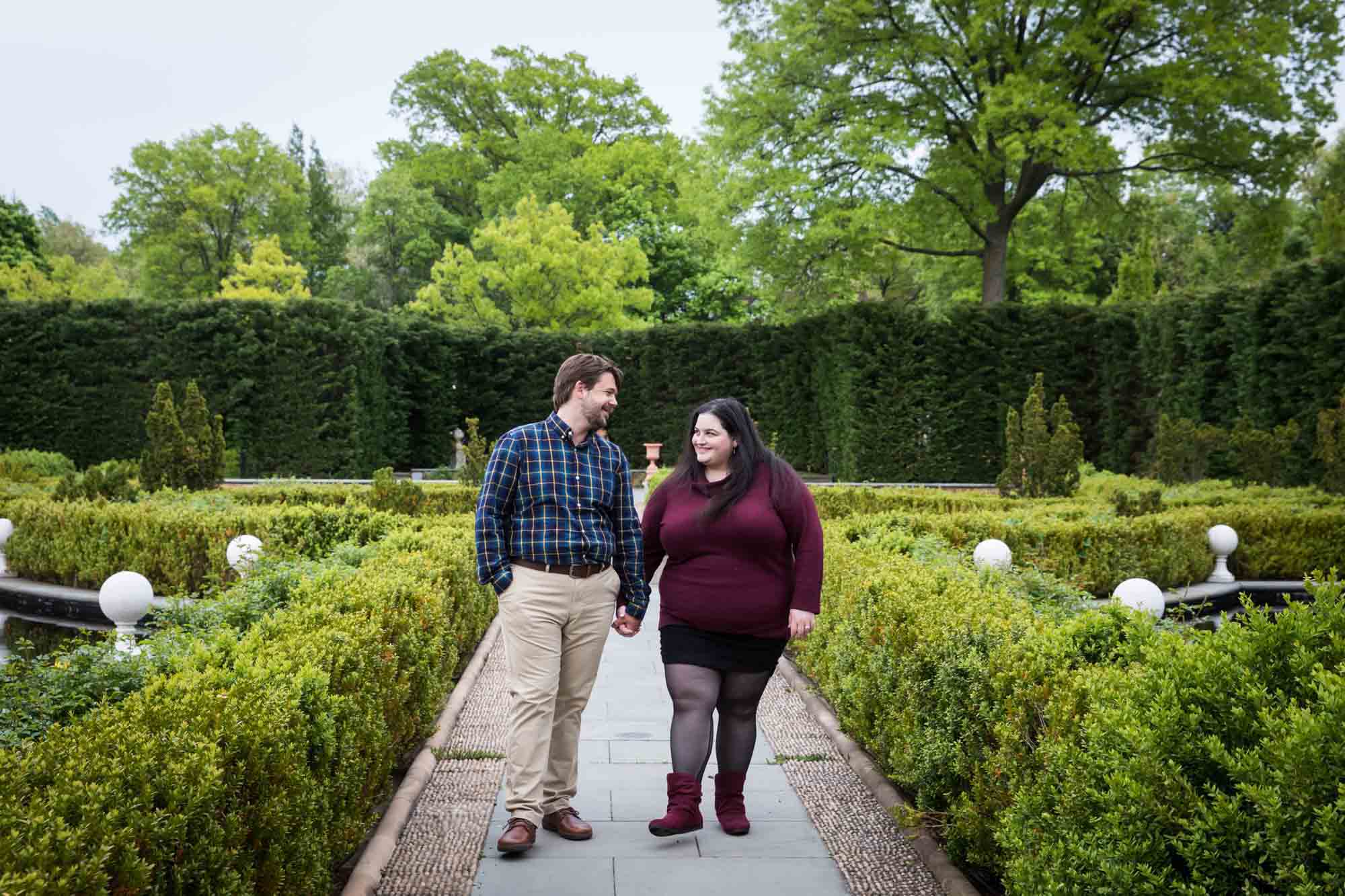 Couple holding hands and walking in Tuscan Garden in Snug Harbor