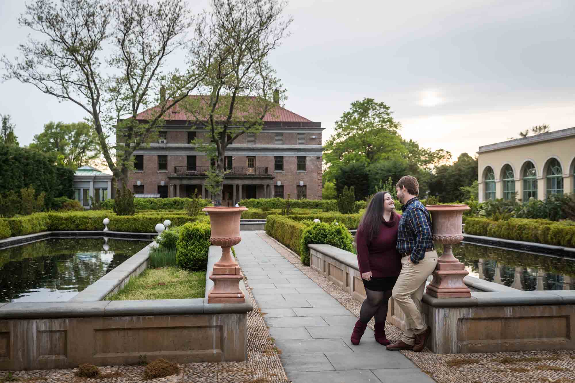 Snug Harbor engagement photos of couple at end of Tuscan Garden pathway