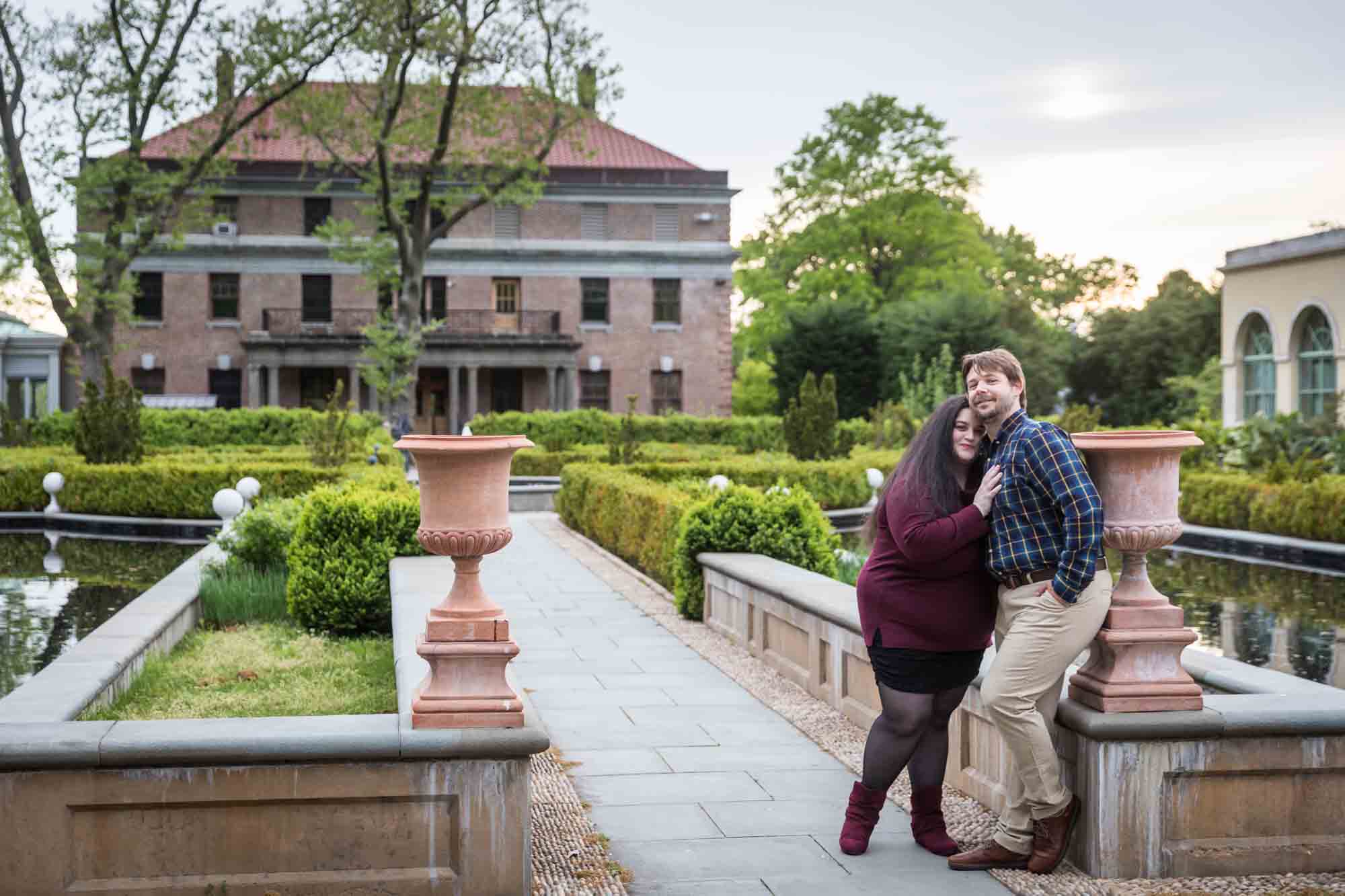 Couple hugging in pathway of Tuscan Garden in Snug Harbor