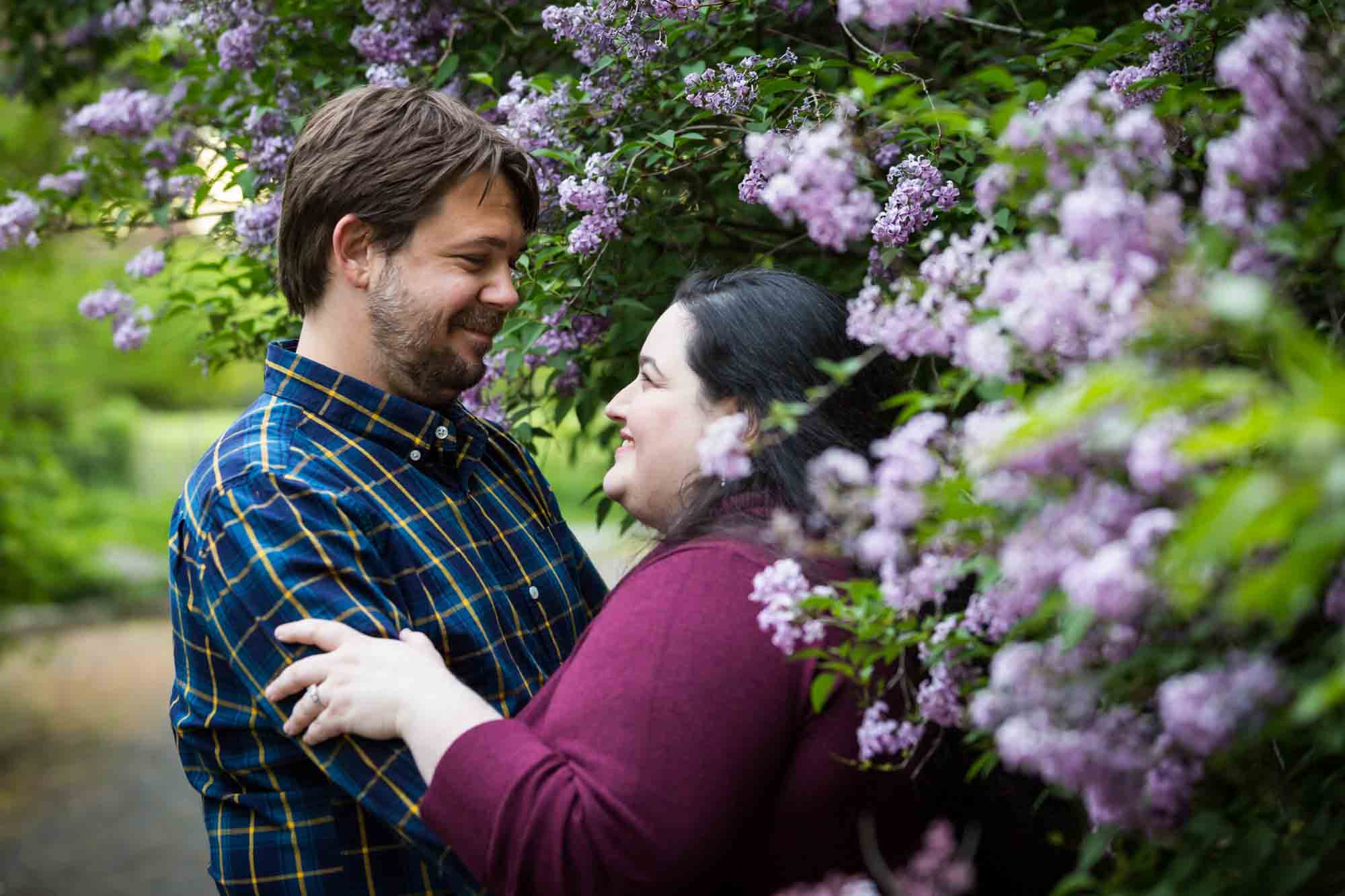 Couple looking at each other in lilac bush in Snug Harbor