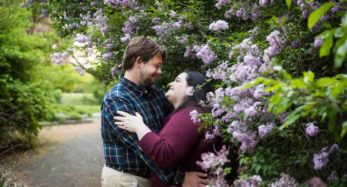 Snug Harbor engagement photos of couple beside lilac bush