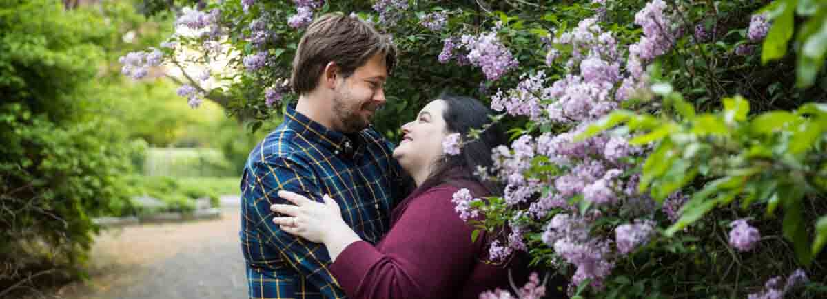 Snug Harbor engagement photos of couple beside lilac bush