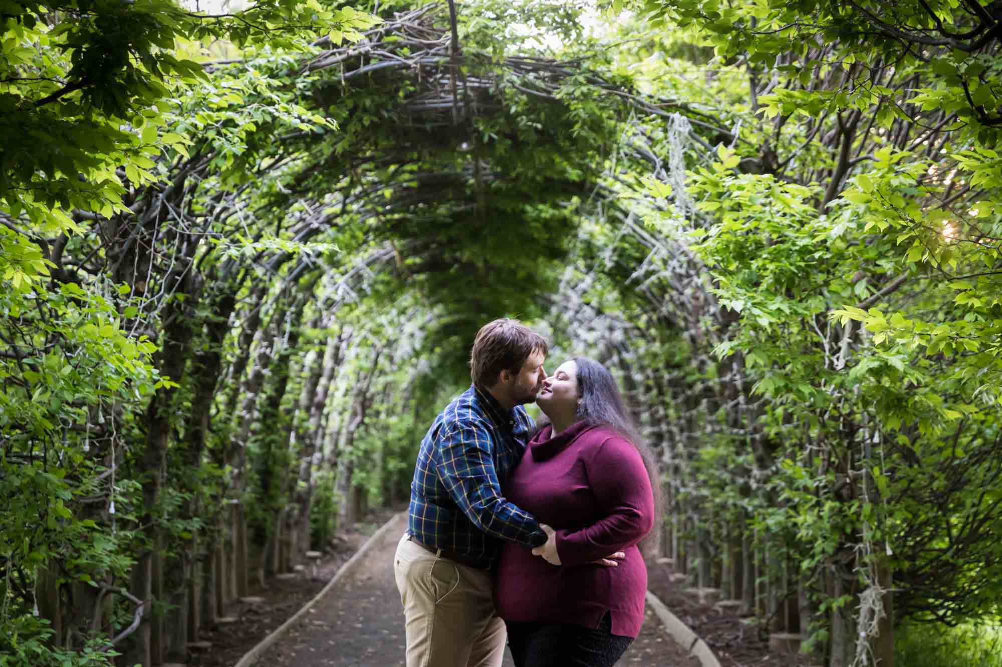 Couple kissing under allee in Snug Harbor