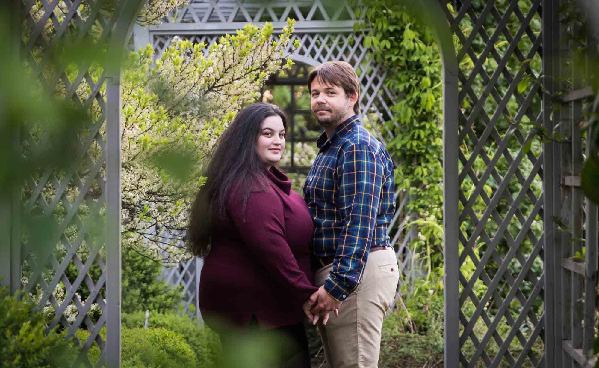 Couple looking through window in White Garden lattice in Snug Harbor