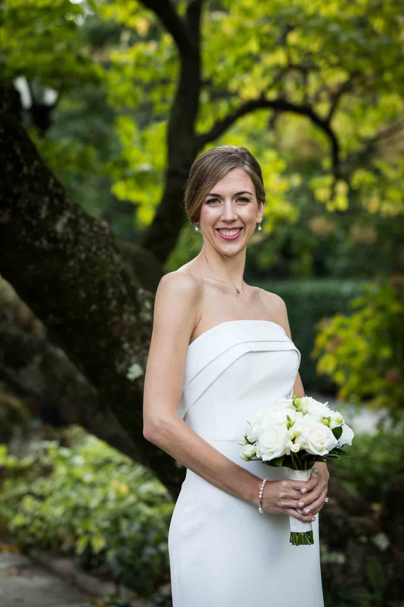 Bride wearing sleeveless wedding dress and holding small bouquet