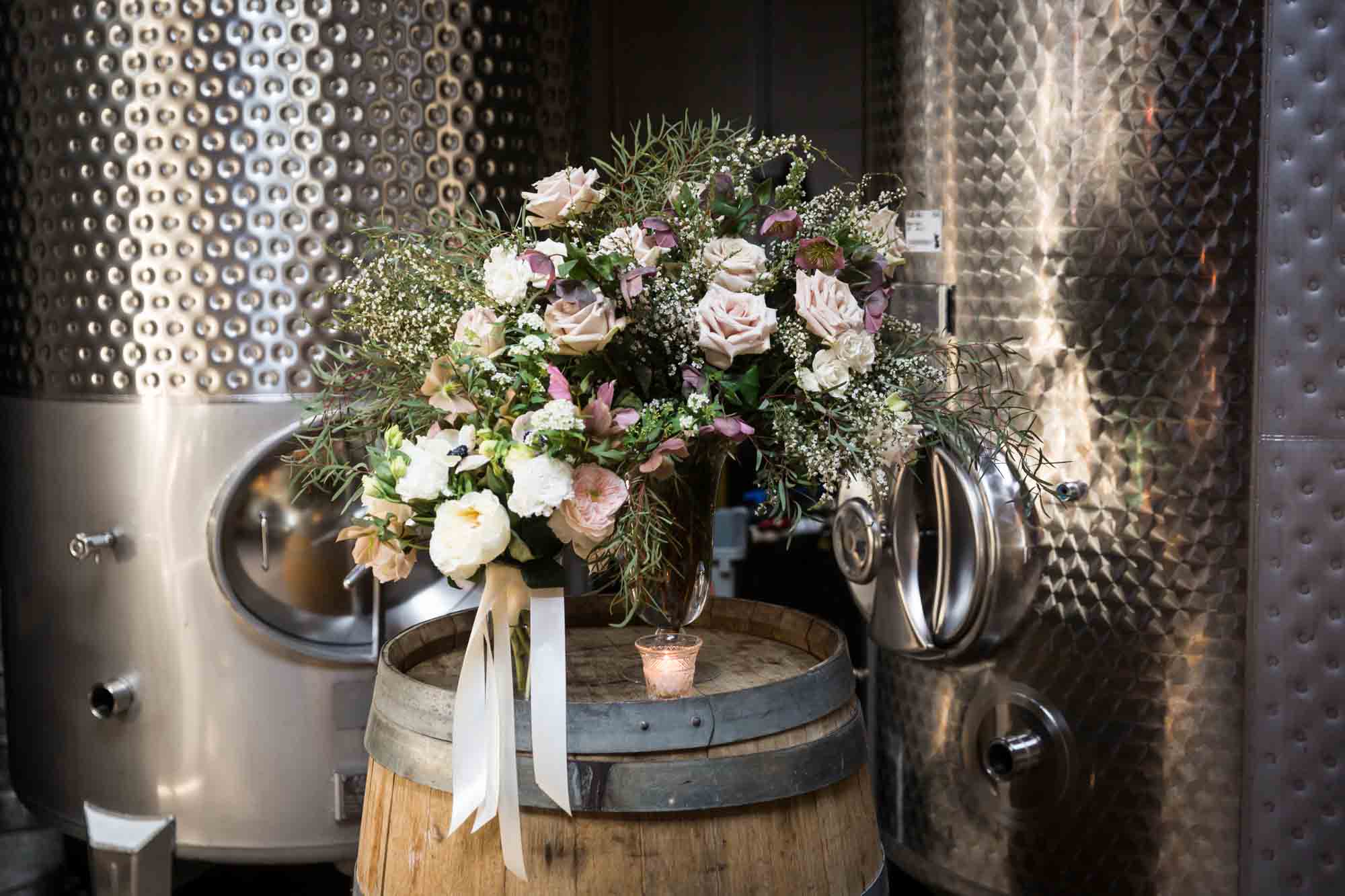 Two pink flower bouquets sitting on top of wooden barrel