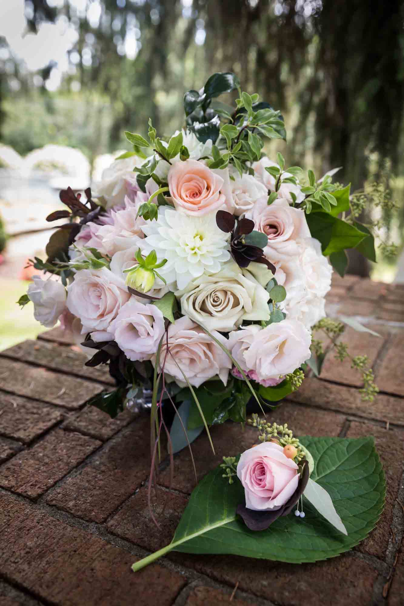 Pink and white flower bouquet sitting on brick wall