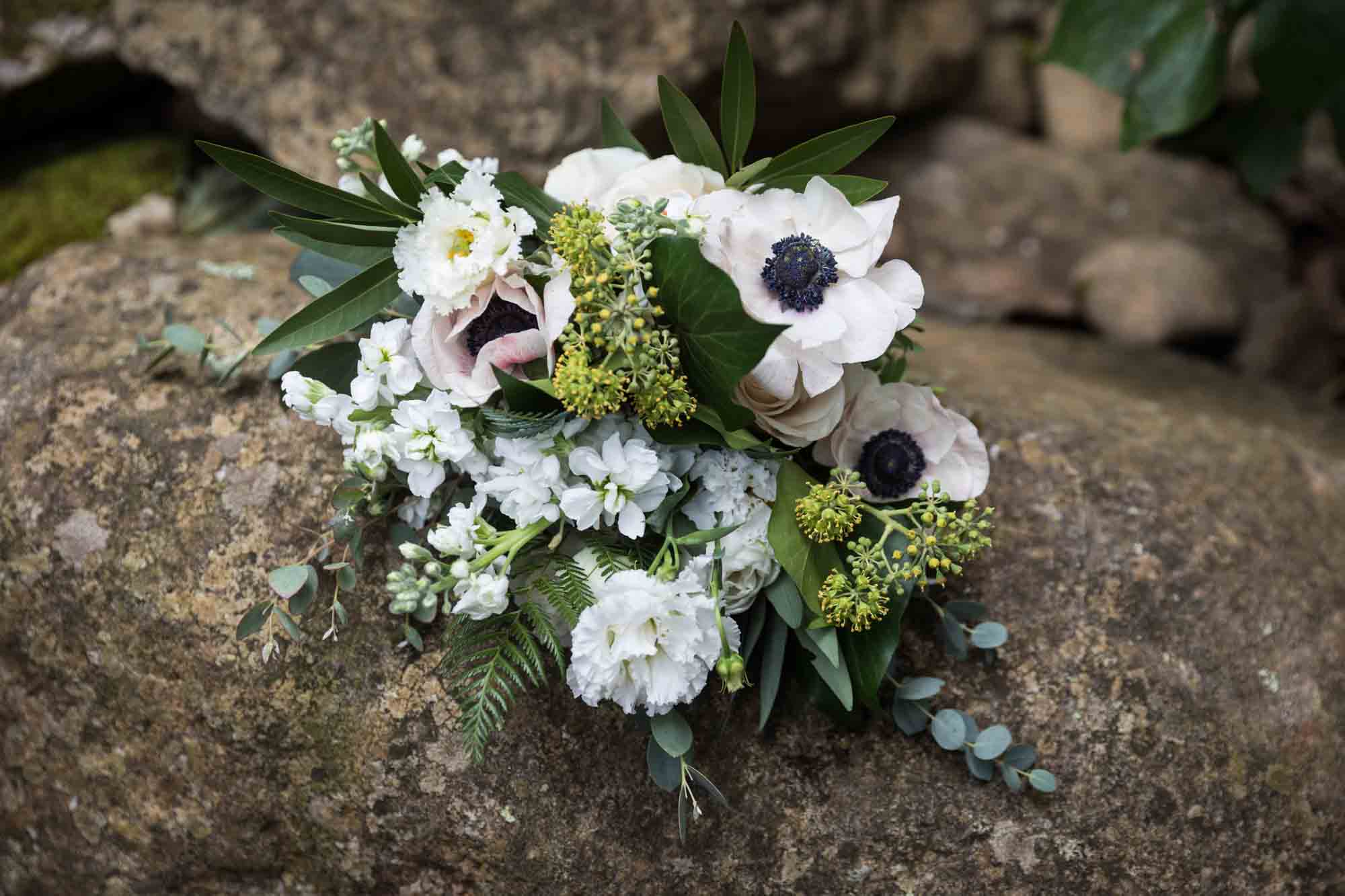 White and purple flower bouquet on rock