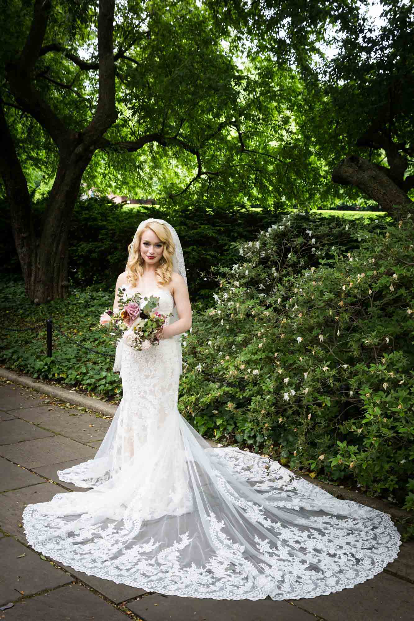 Bride wearing dress with long train in Central Park