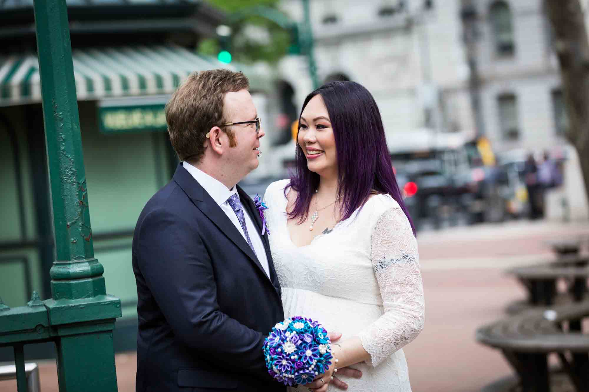 Bride holding brooch bouquet and groom on NYC street