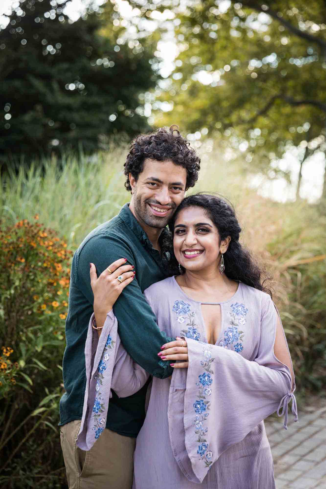 Battery Park engagement photos of couple hugging in front of tall grass