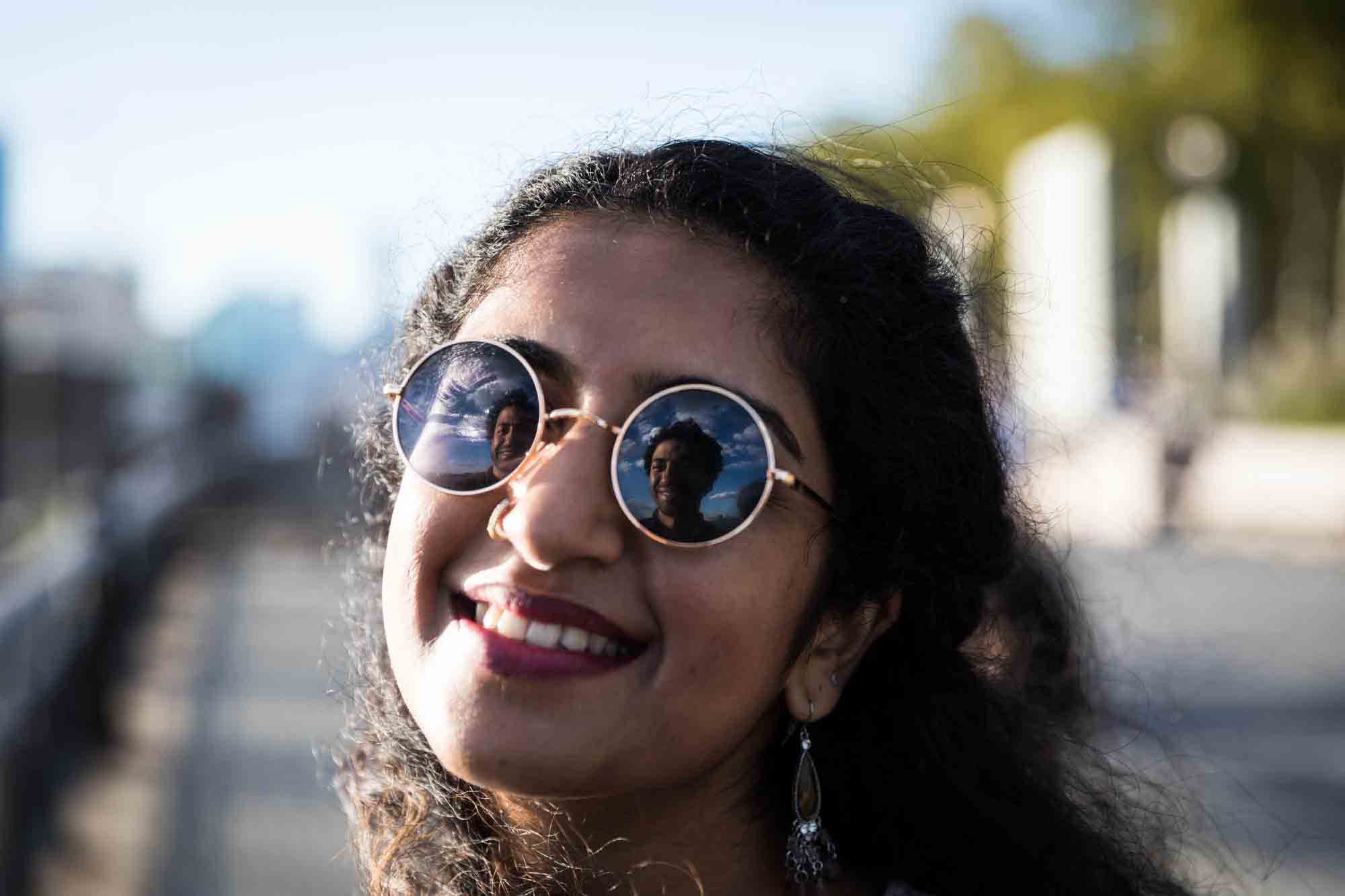 Smiling woman with reflection of fiance in her sunglasses