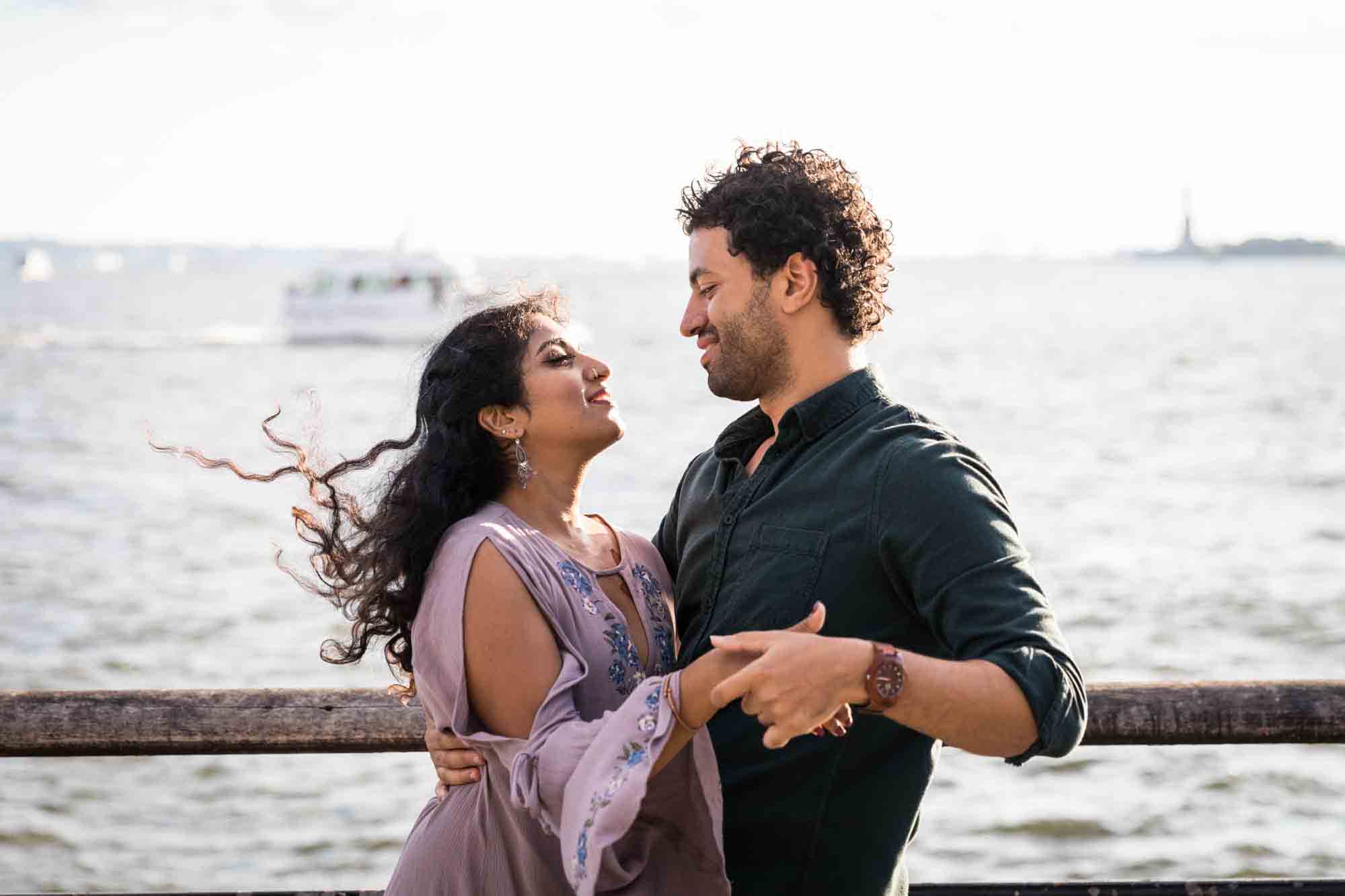 Battery Park engagement photos of couple dancing in front of NYC waterfront