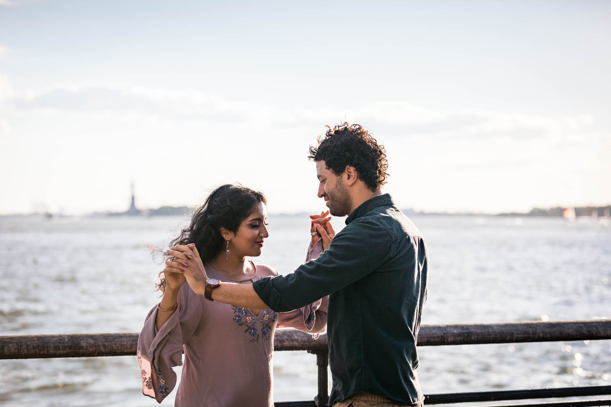 Battery Park engagement photos of couple dancing in front of NYC waterfront