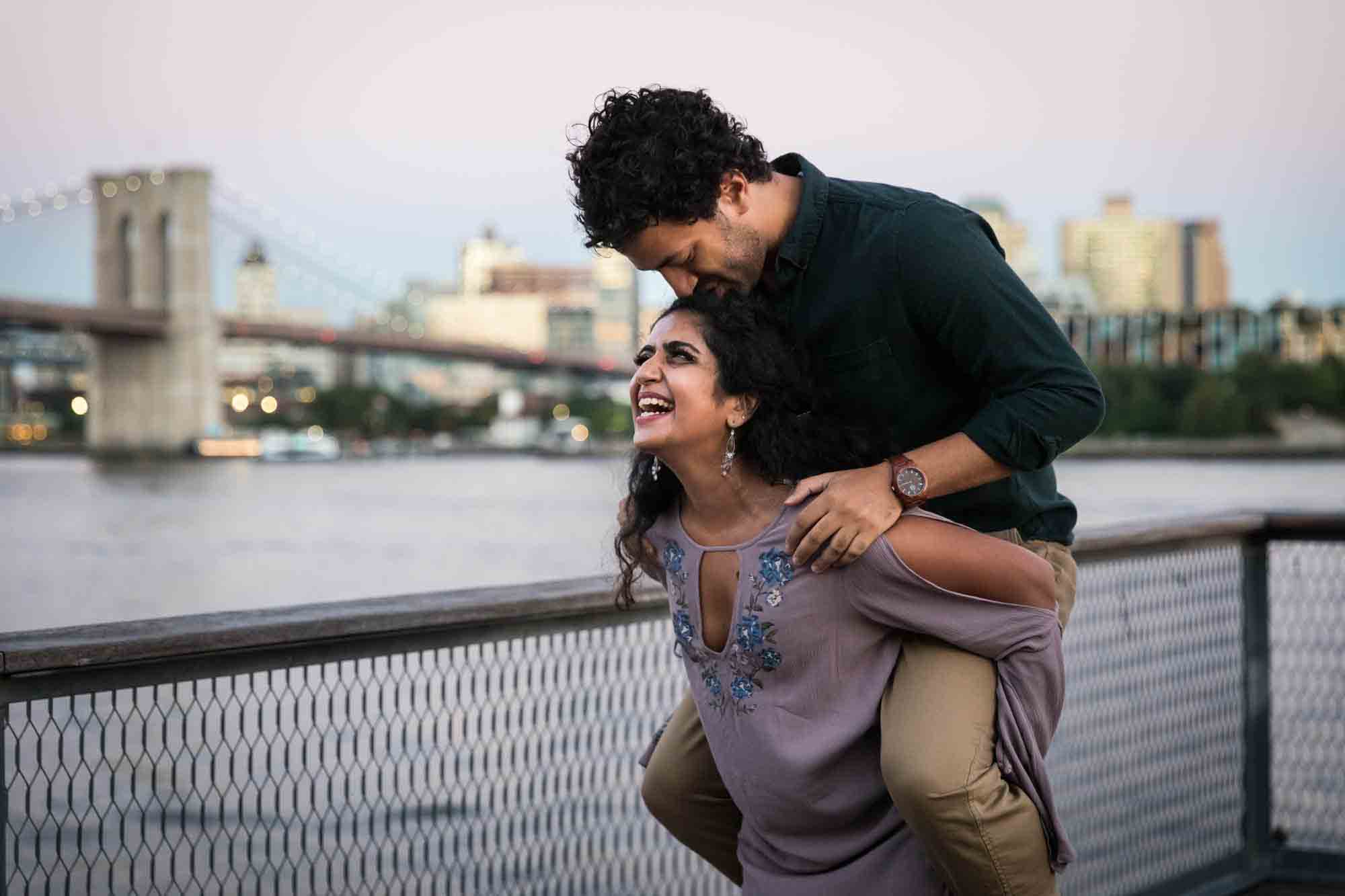 Woman giving man a piggyback ride on Pier 17