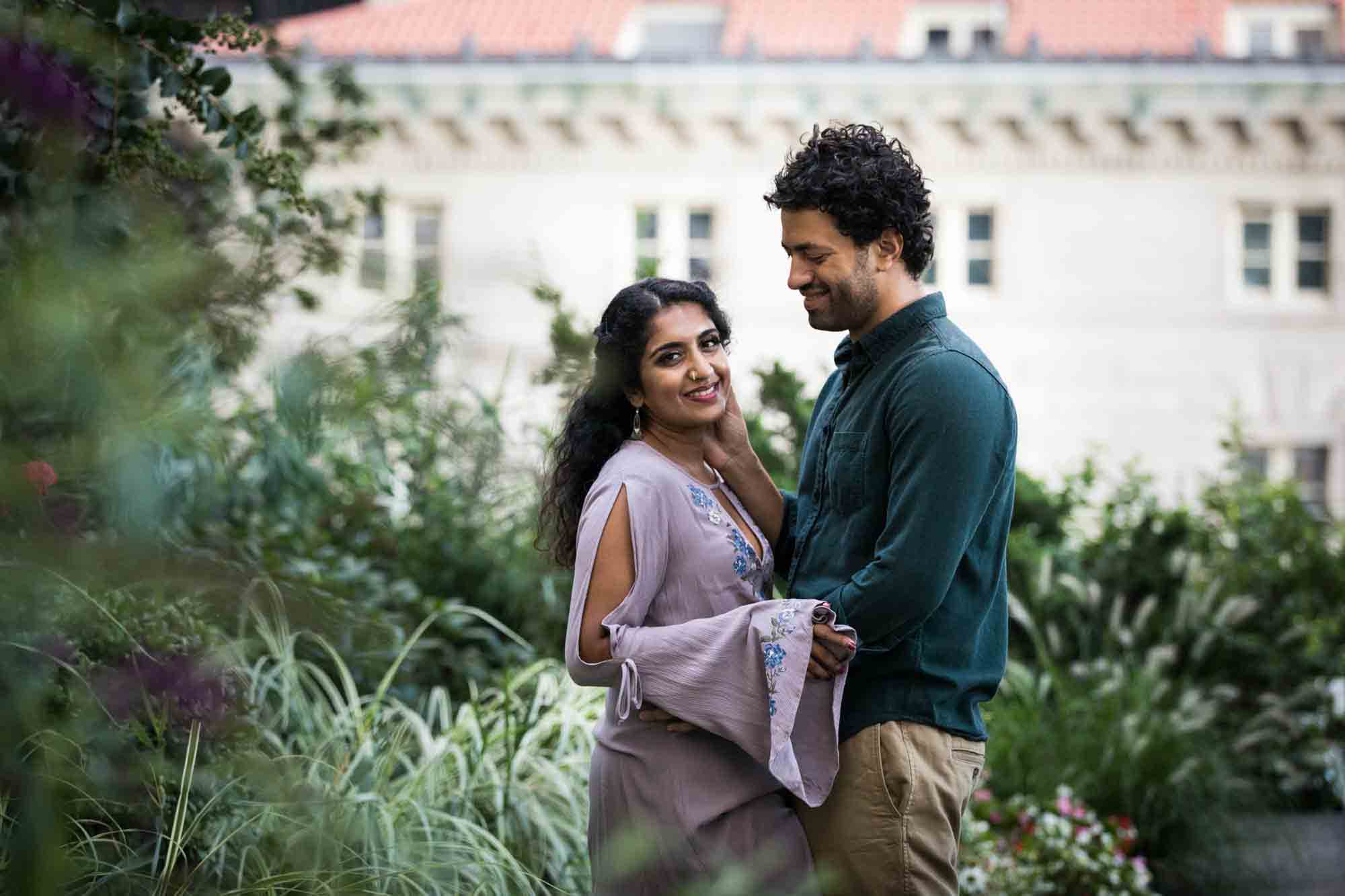 Couple hugging in front of plants at Elevated Acre