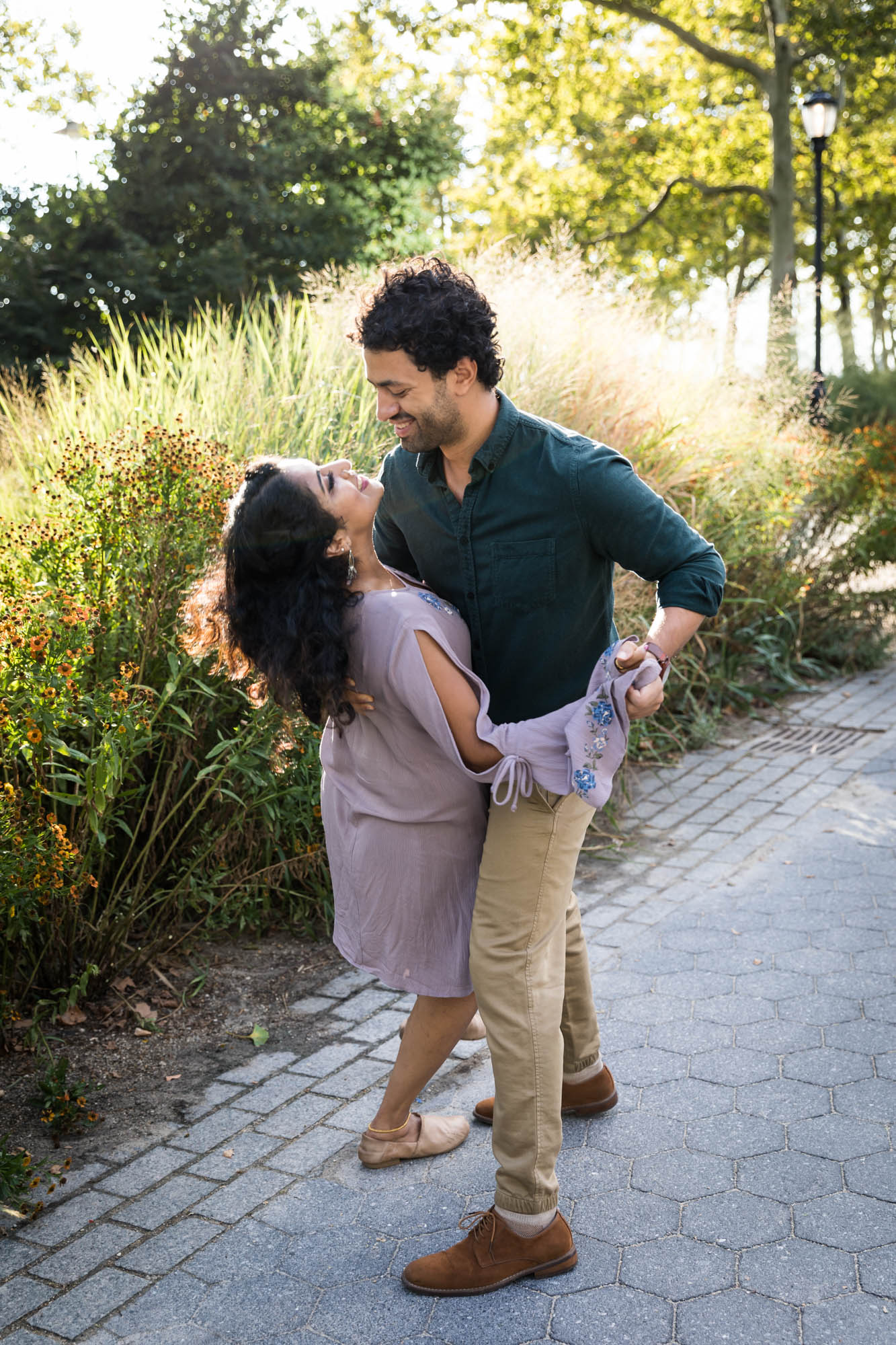 Battery Park engagement photos of couple dancing in front of tall grass