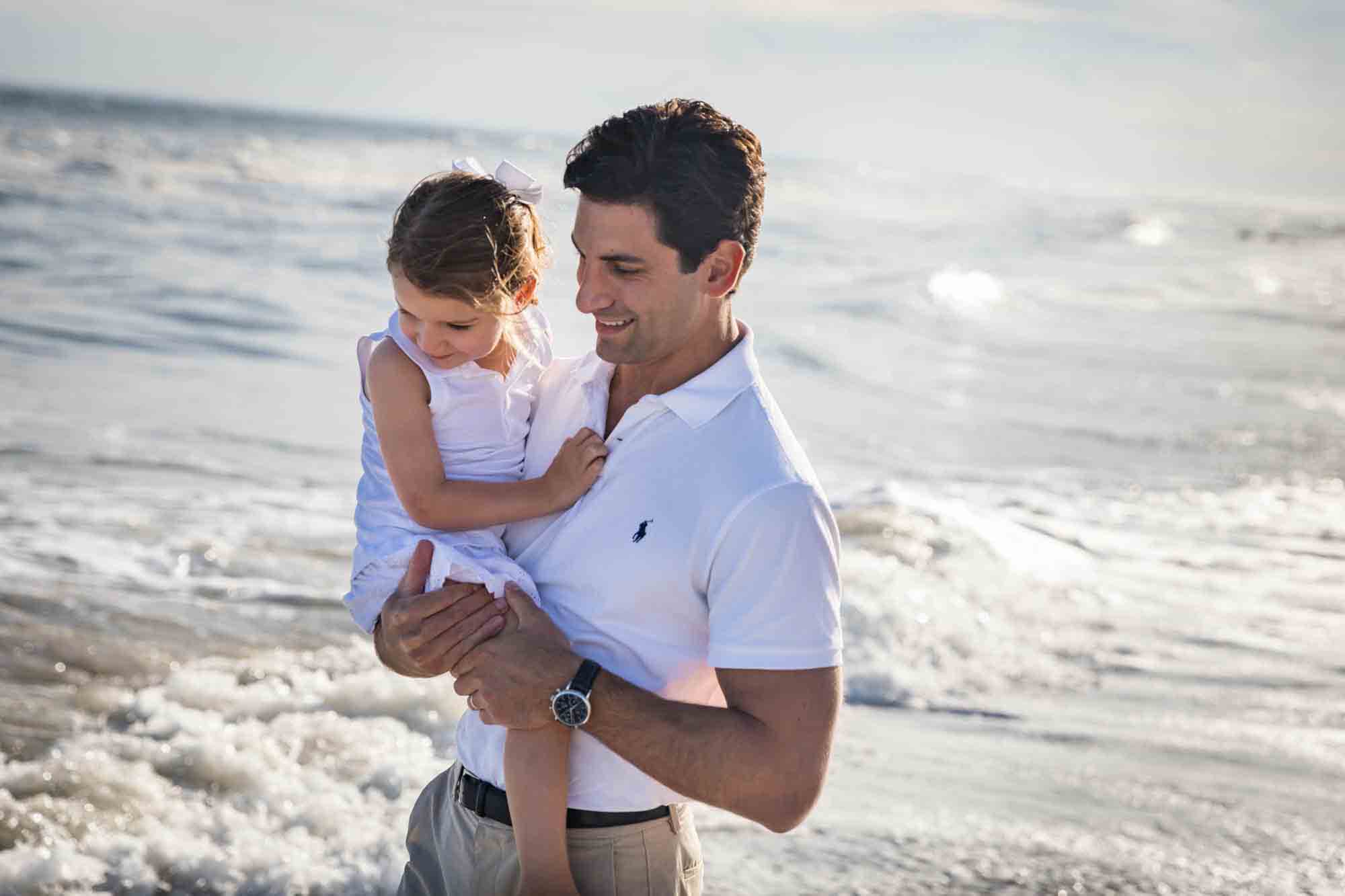 Fort Tilden beach family portrait of father holding small girl in ocean