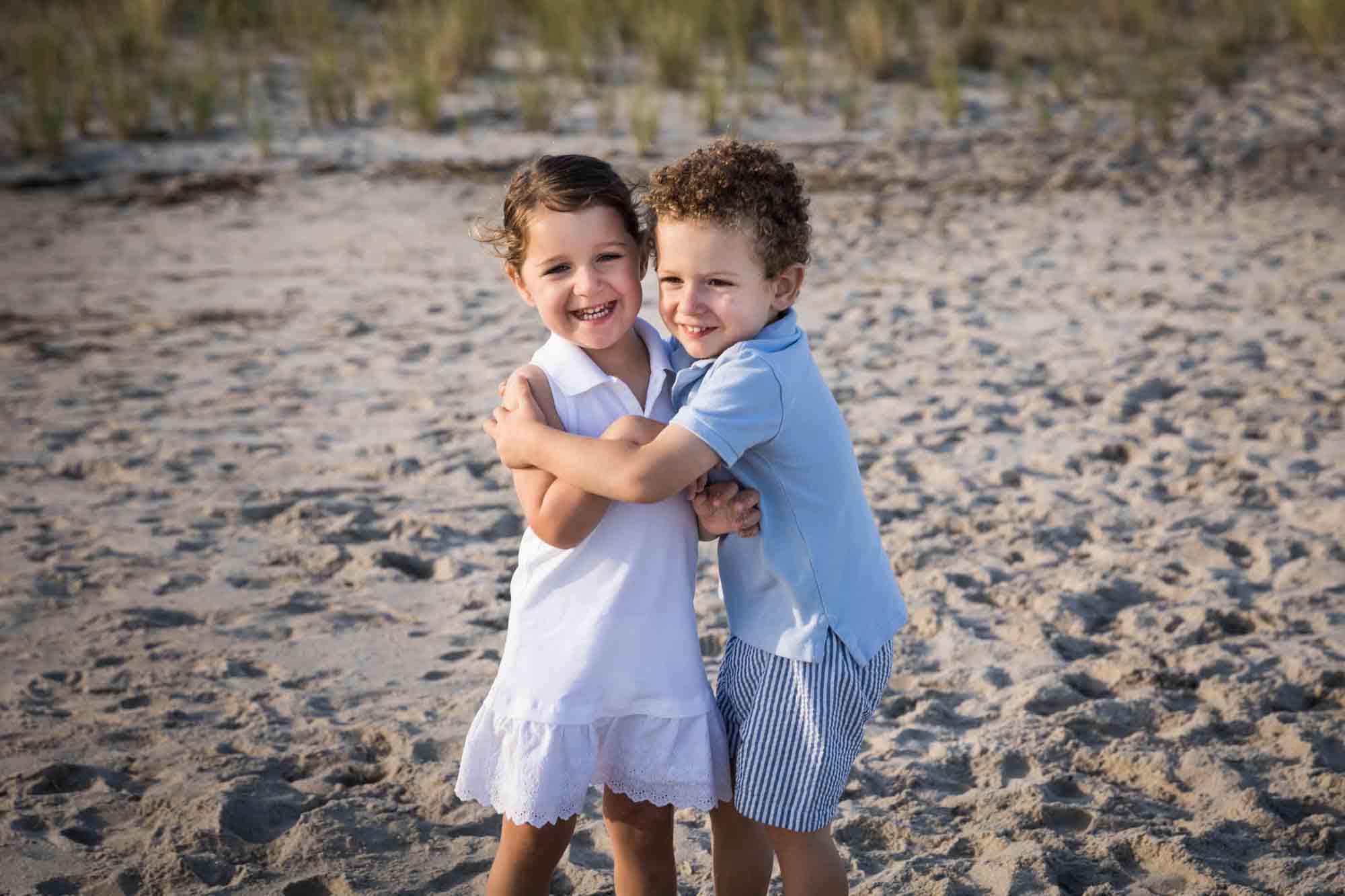 Fort Tilden beach family portrait of two small children hugging on the beach