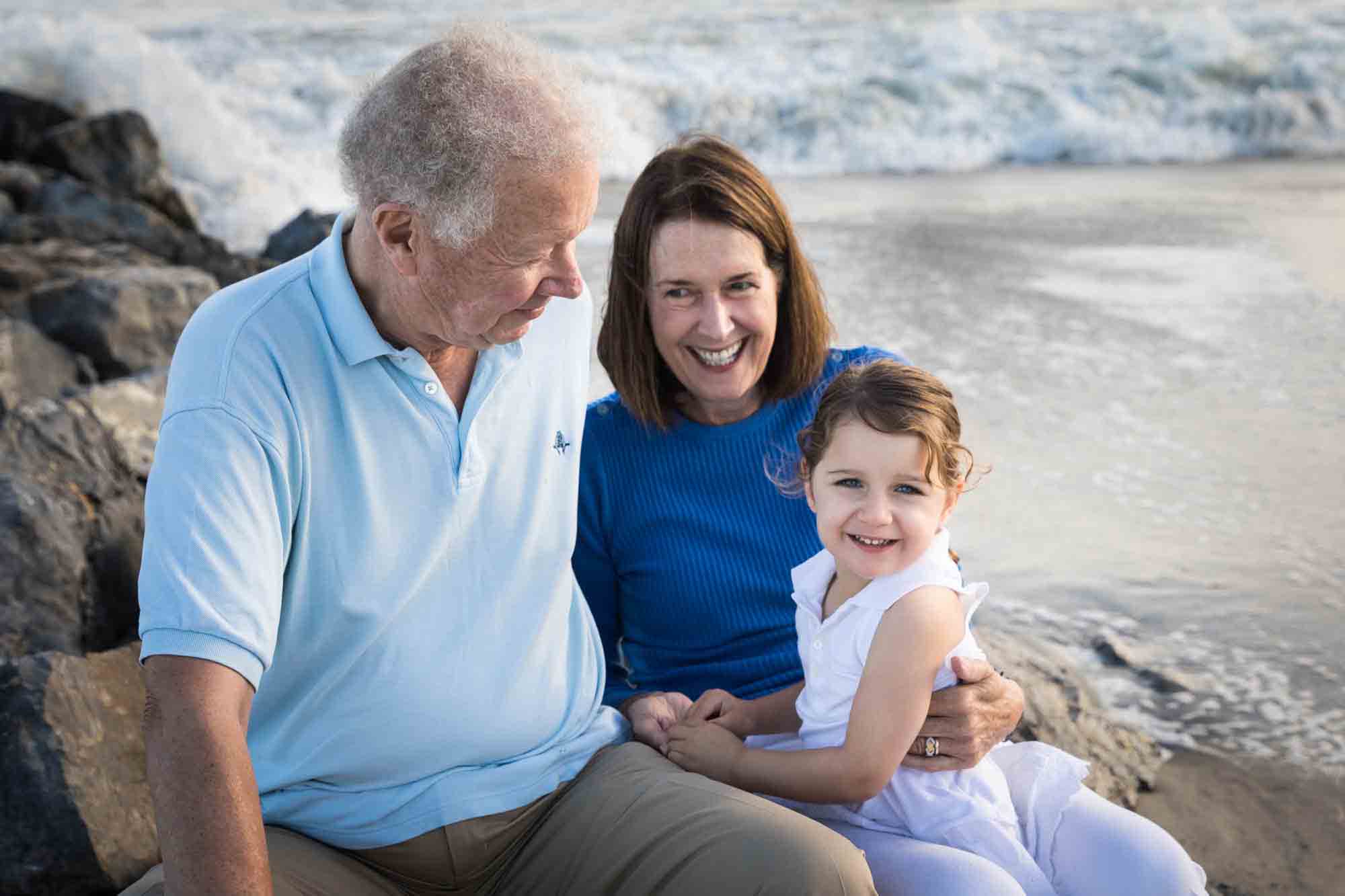 Fort Tilden family portrait of grandparents with small girl in front of the ocean