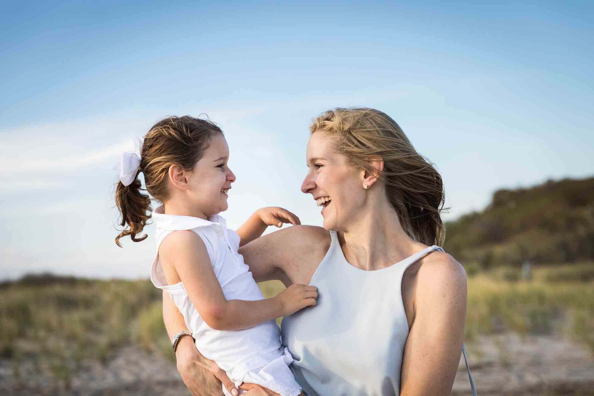 Beach family portrait of mother with blond hair holding small girl