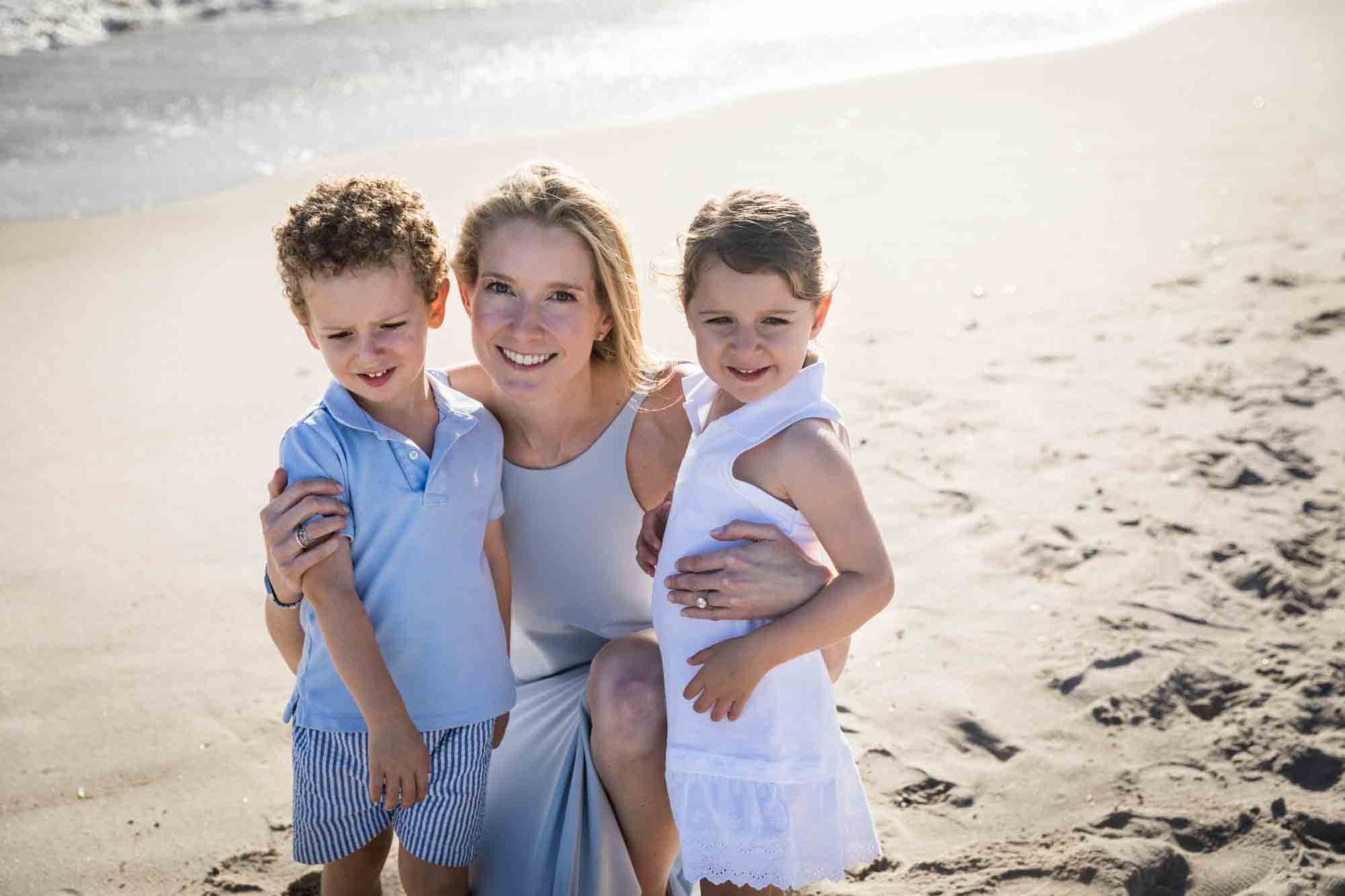 Mother with two small children on a beach for an article on beach family portrait tips