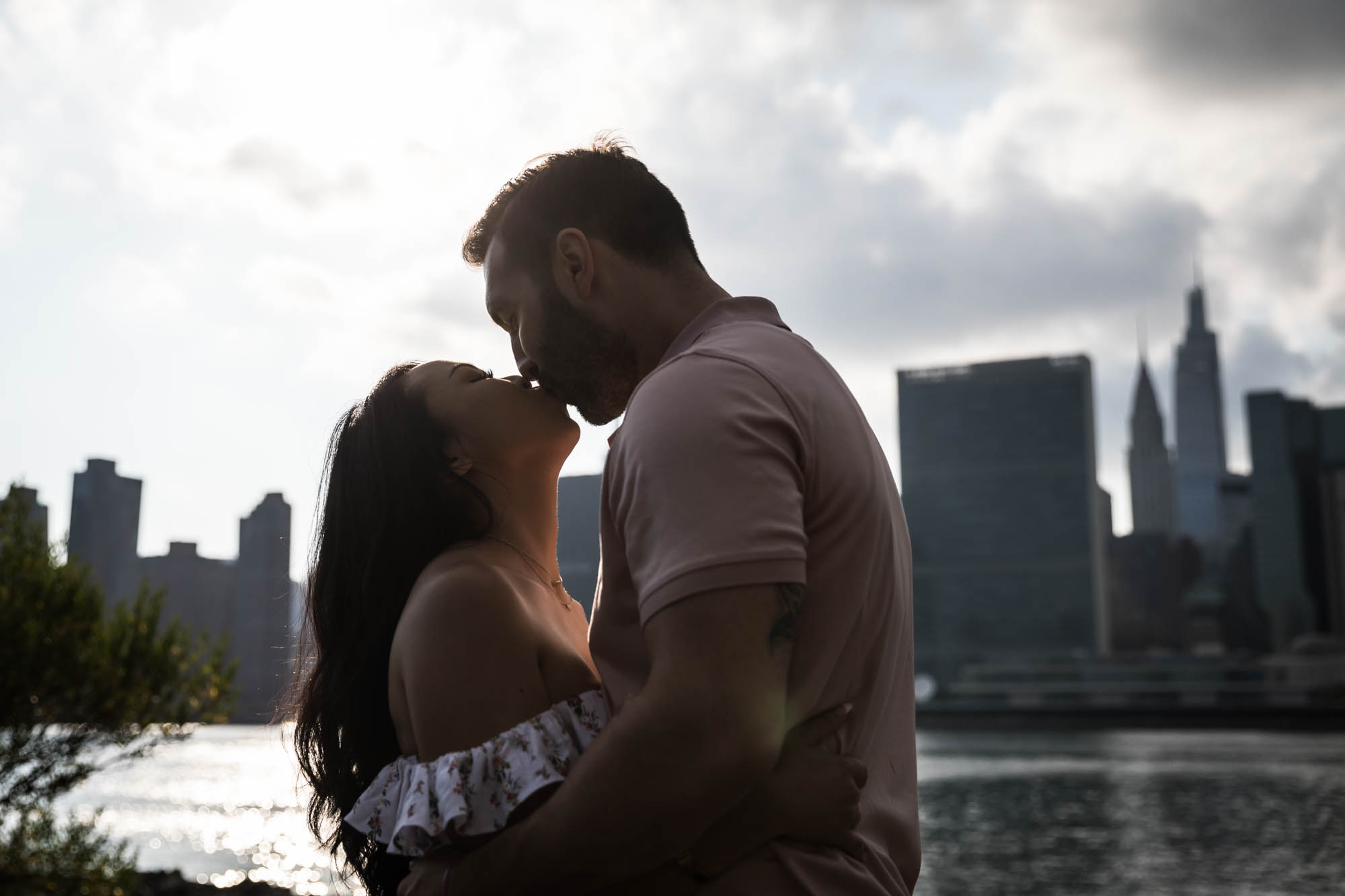 Backlit photo of couple kissing during a Gantry Plaza State Park engagement photo shoot