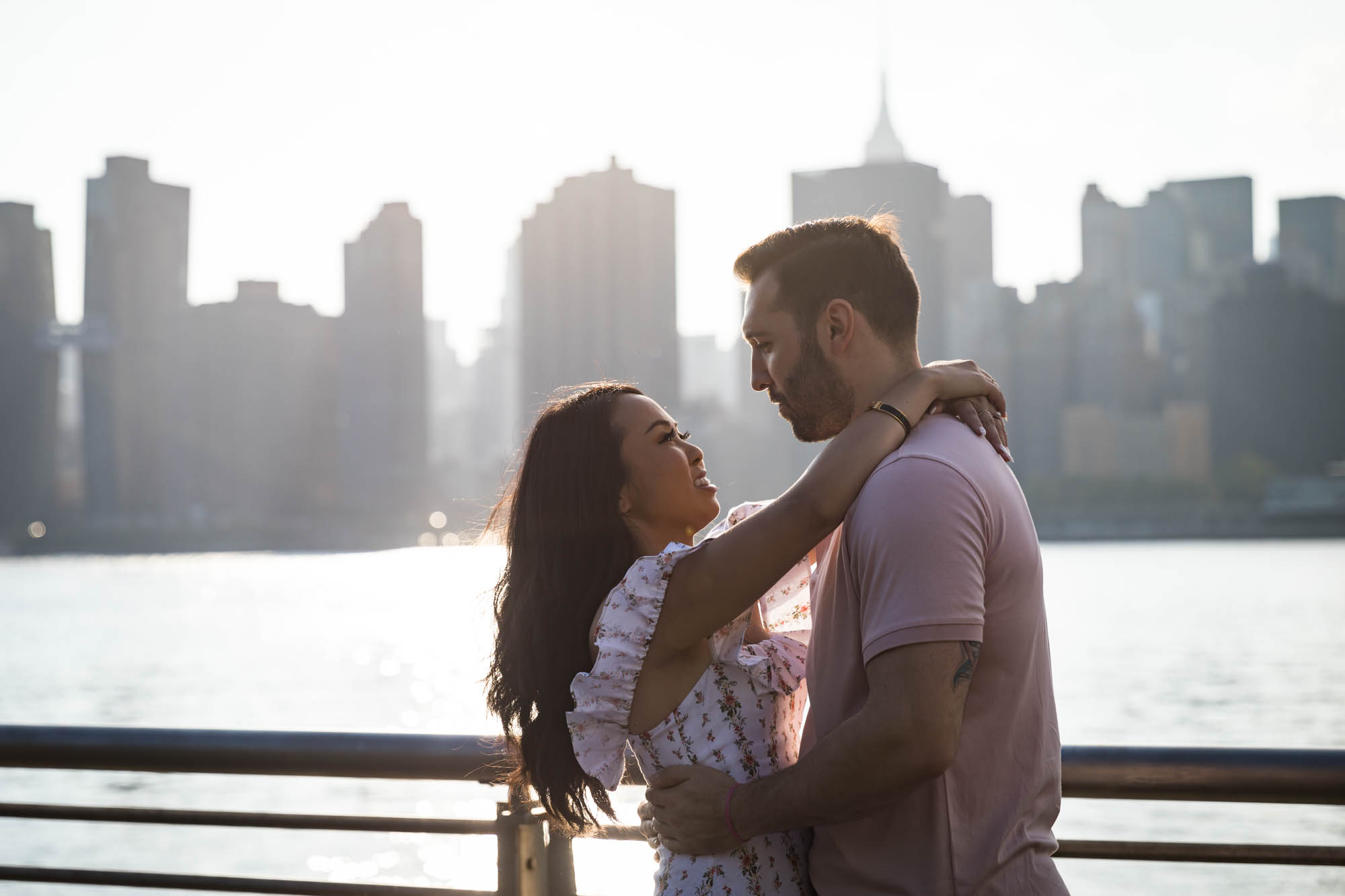 Couple hugging with NYC skyline in background at sunset