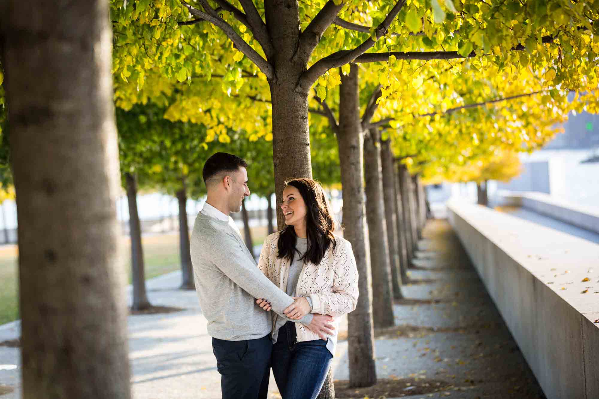Couple hugging in front of trees during a Four Freedoms Park engagement photo shoot
