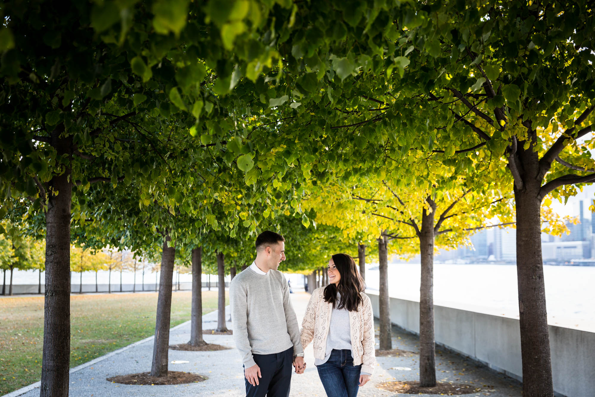 Couple looking at each other under trees during a Four Freedoms Park engagement photo shoot