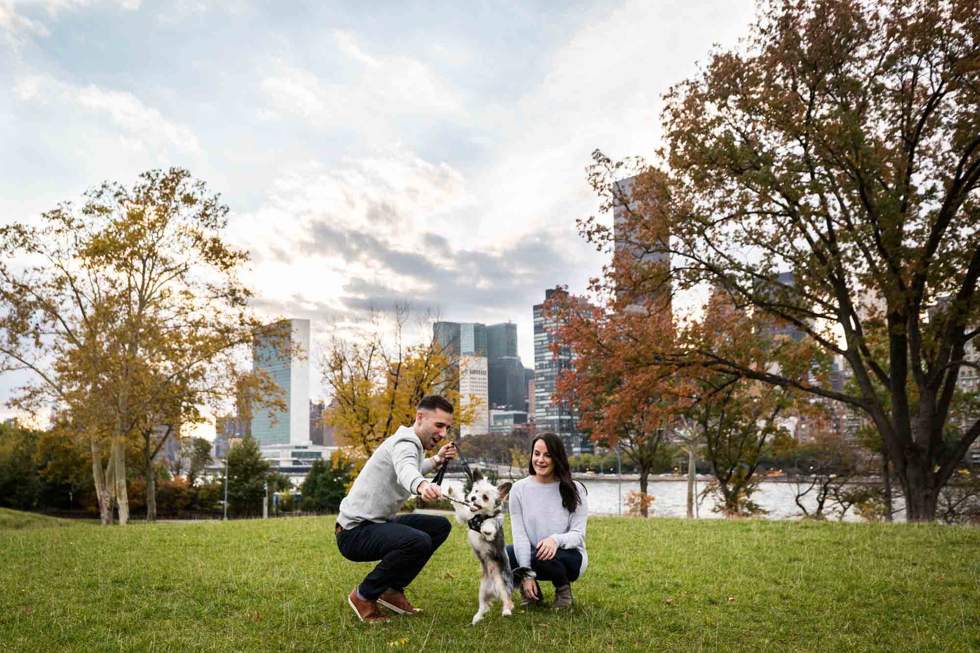 Couple playing with dog on grass for an article on pet engagement photo tips