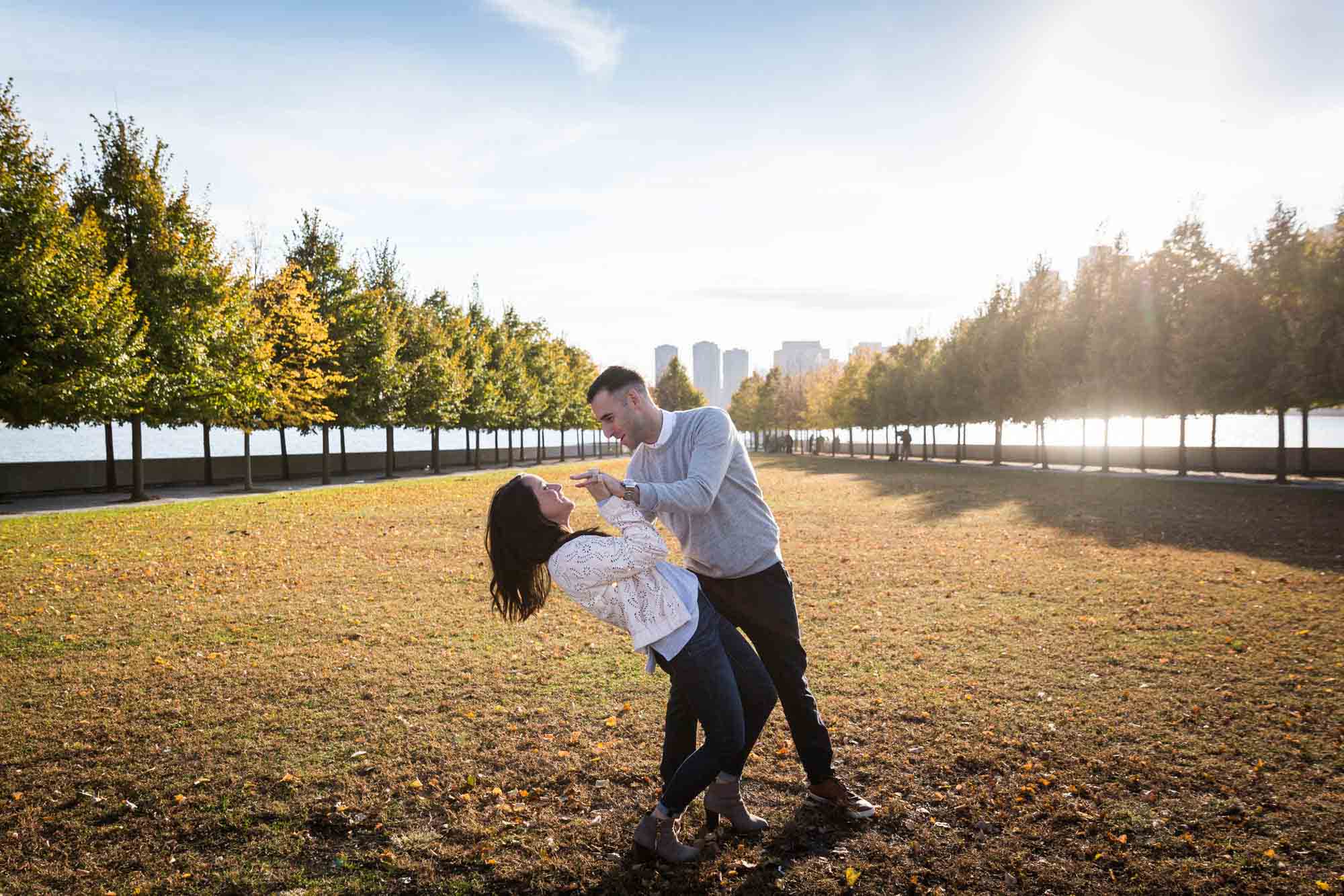 Couple dancing in grass during a Roosevelt Island engagement photo shoot