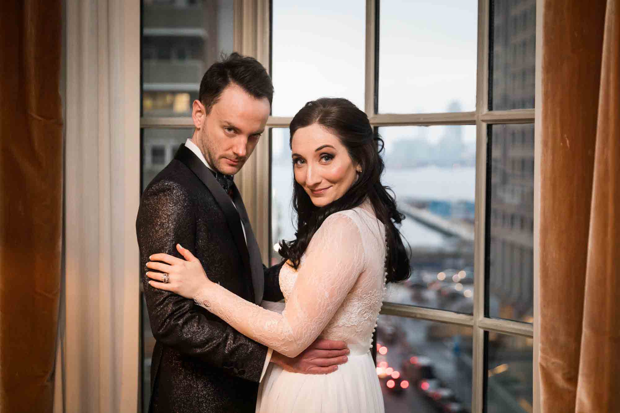 Bride and groom standing in front of window for an article on wedding ceremony photo tips