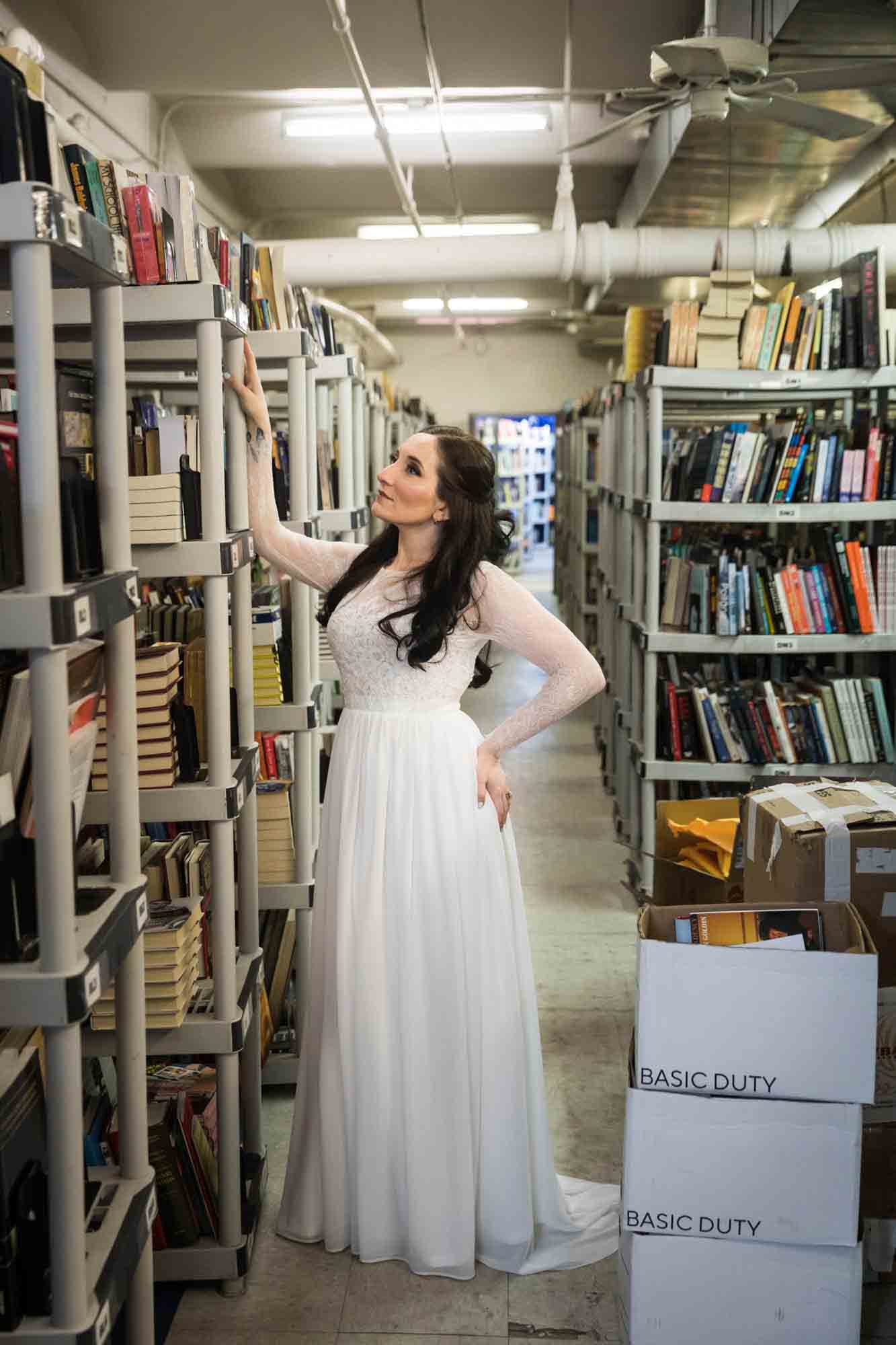 Bride holding on to bookcase at a Housing Works Bookstore wedding