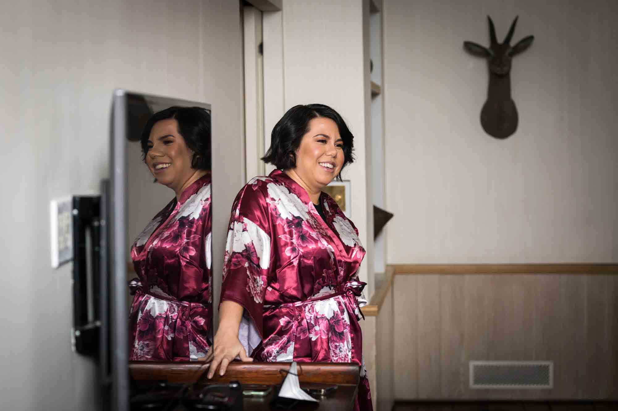 Bridesmaid wearing pink robe reflected in mirror