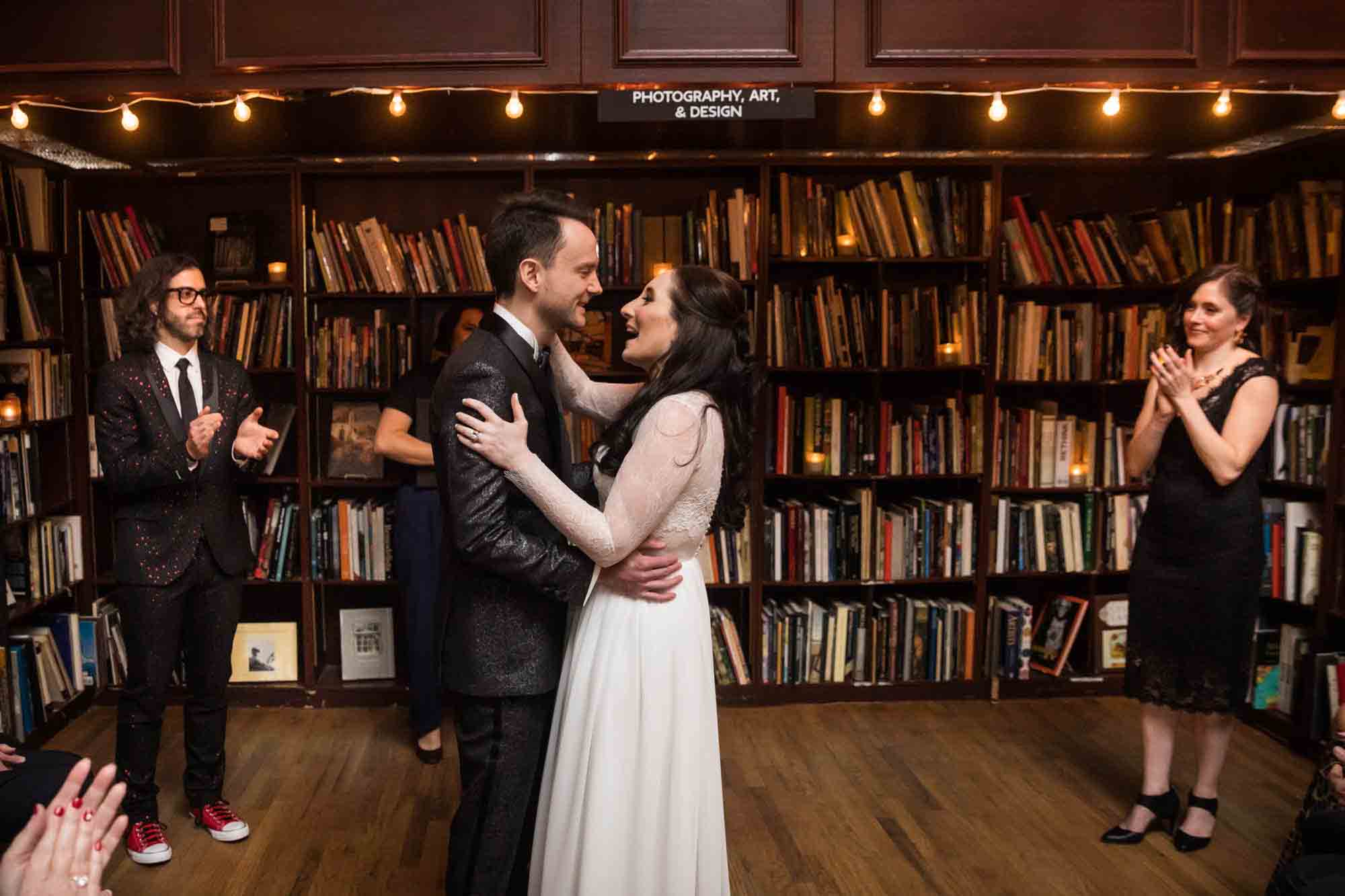 Bride and groom hugging in bookstore for an article on wedding ceremony photo tips