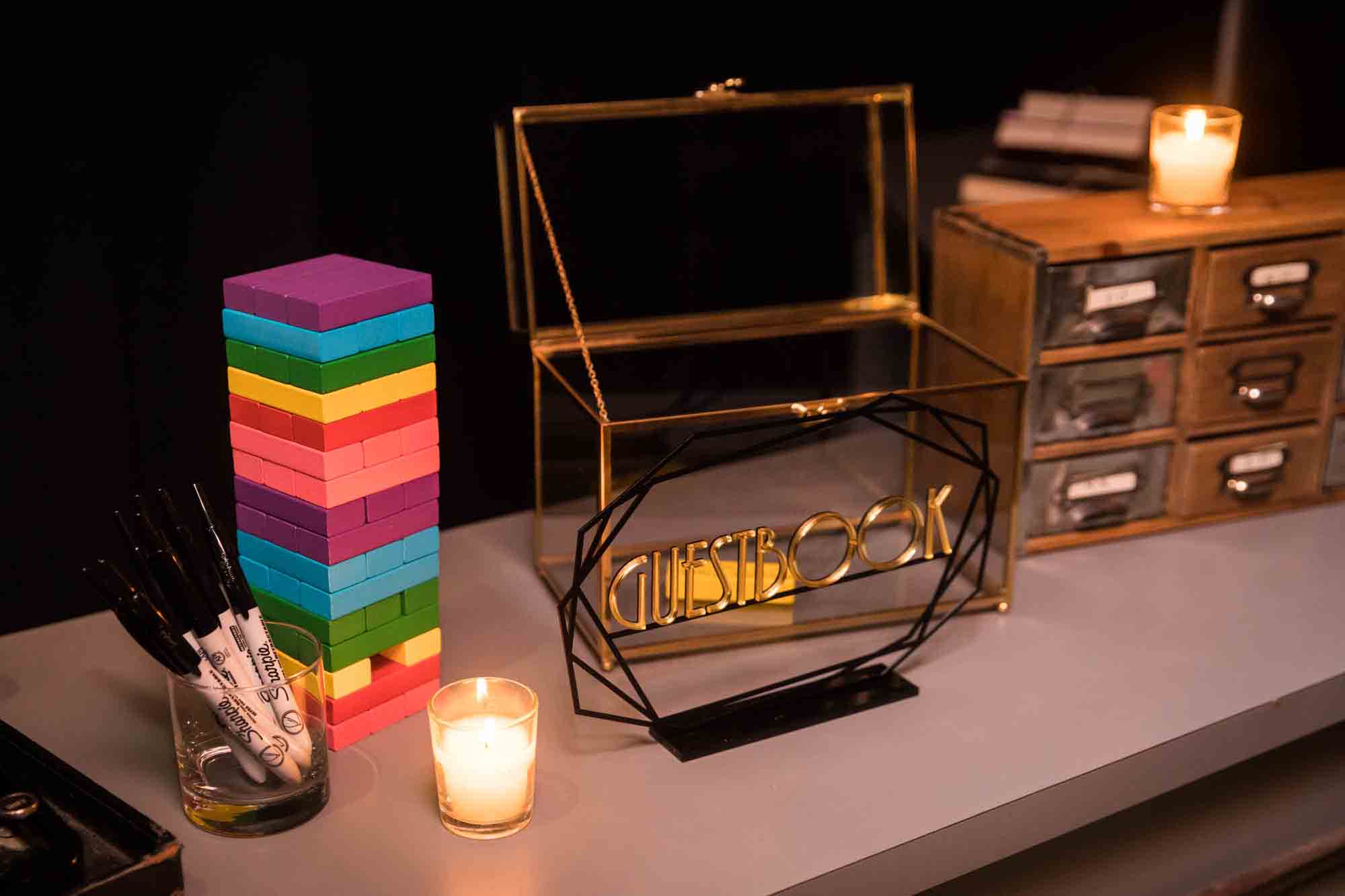 Jenga guest book with colorful blocks and candle