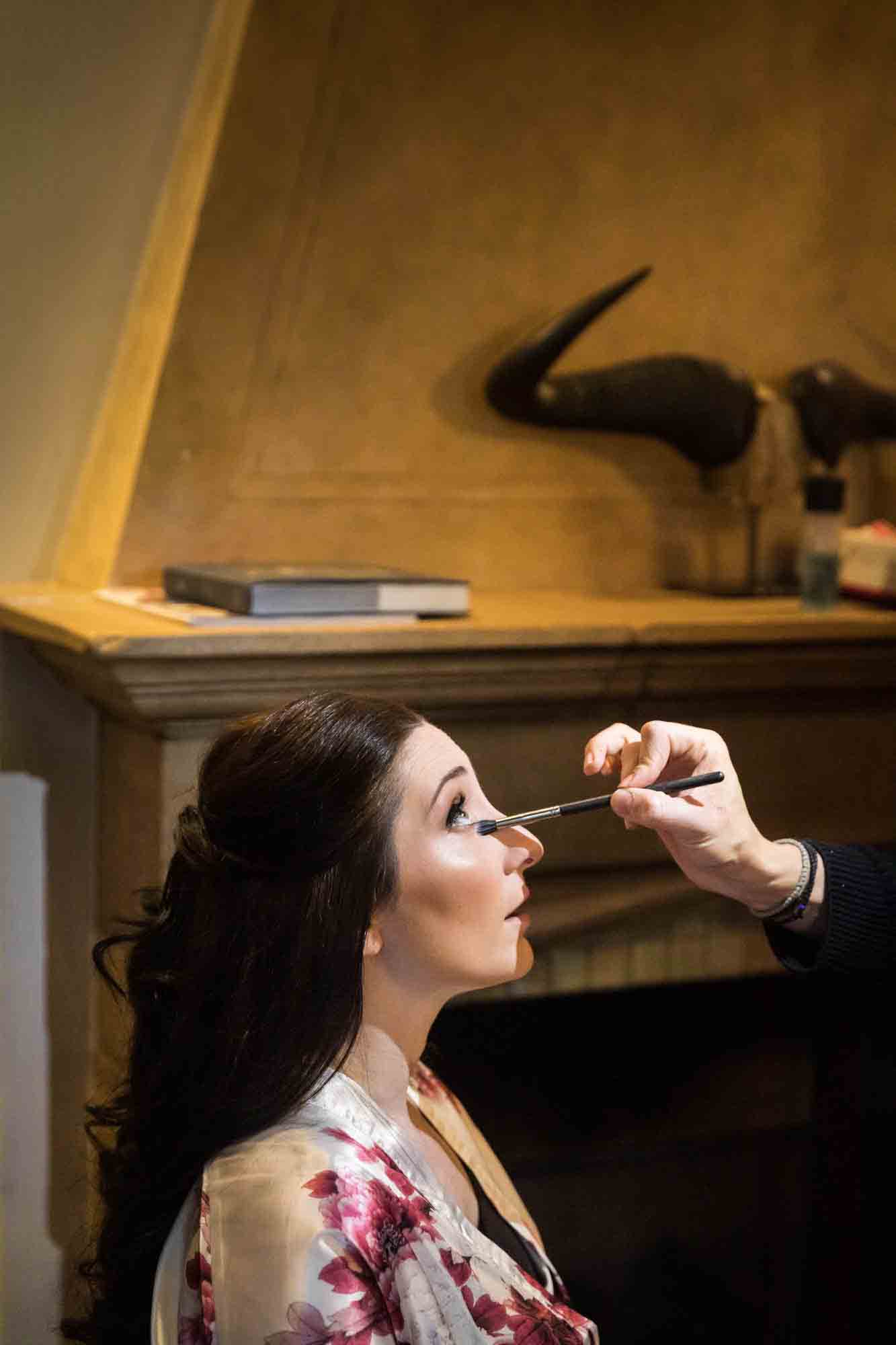 Eye makeup being applied to woman sitting