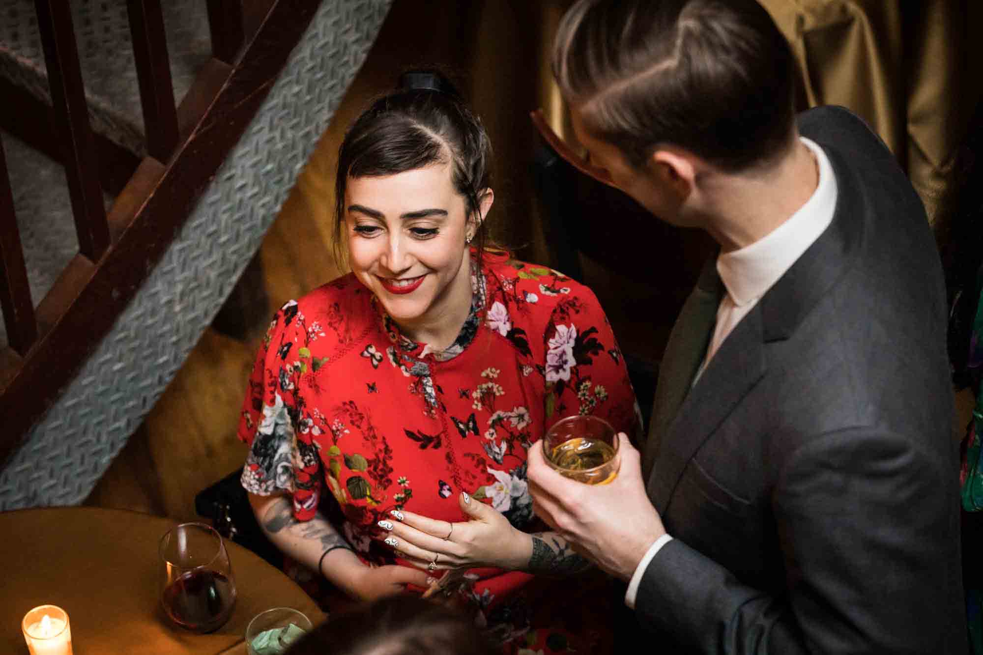 Woman in red dress smiling talking to man for an article on wedding ceremony photo tips