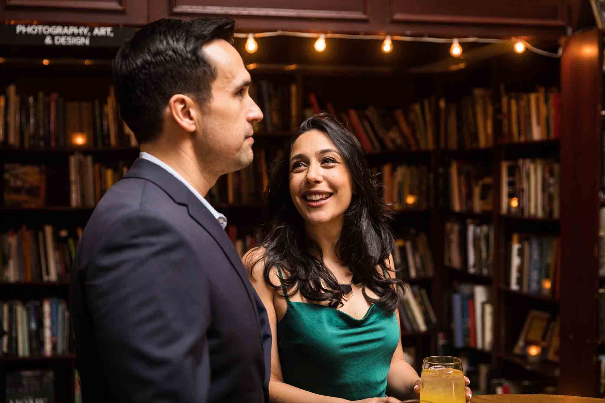 Couple chatting in front of bookcases for an article on wedding ceremony photo tips