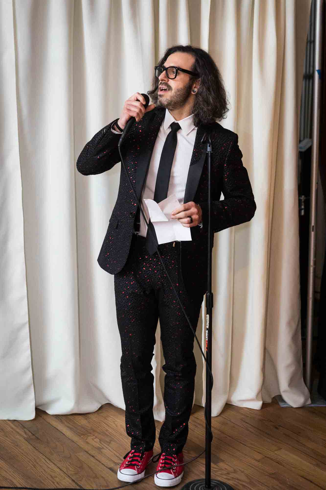 Best man speaking into microphone at a Housing Works Bookstore wedding