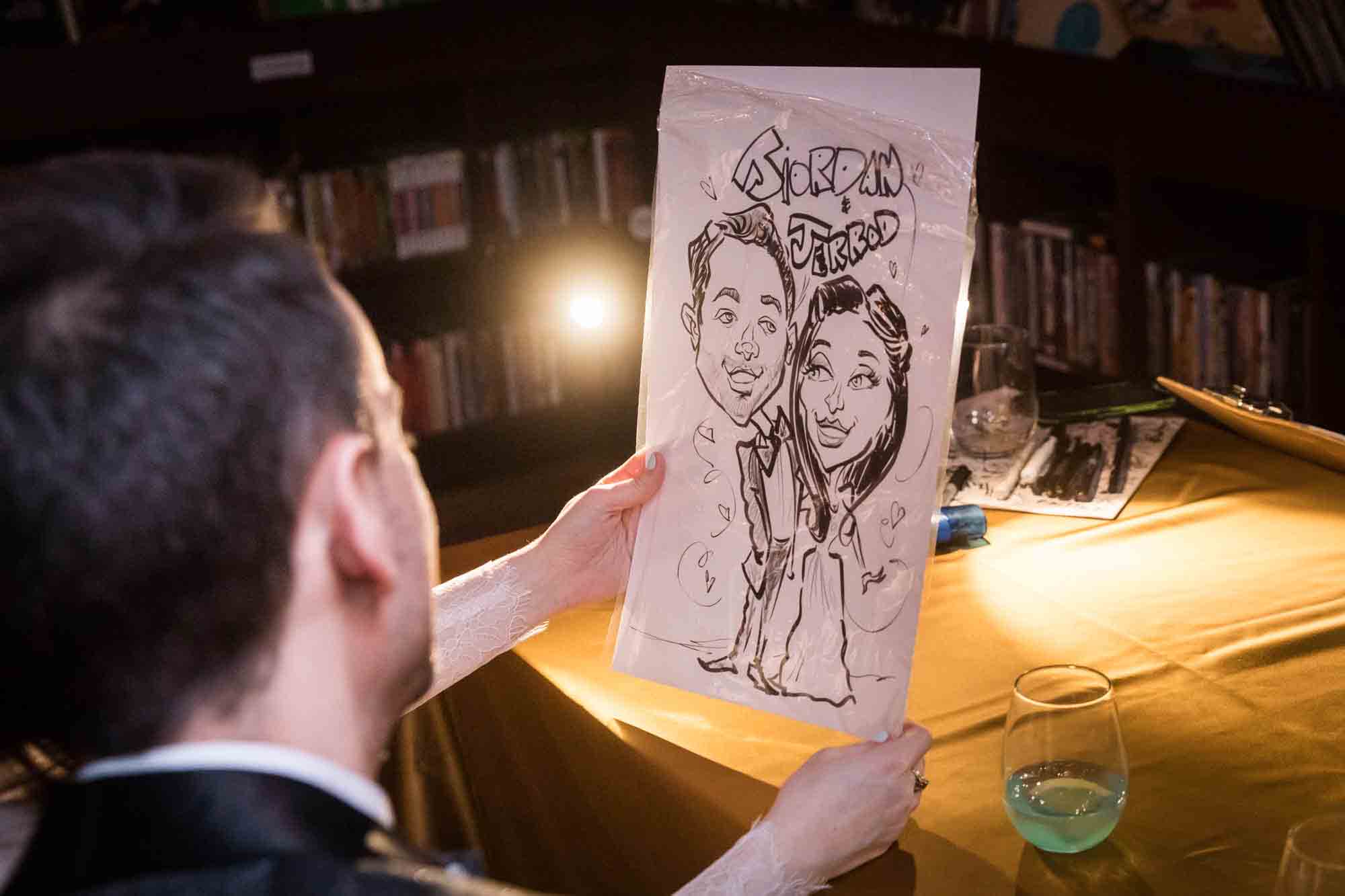 Couple looking at caricature drawing on paper