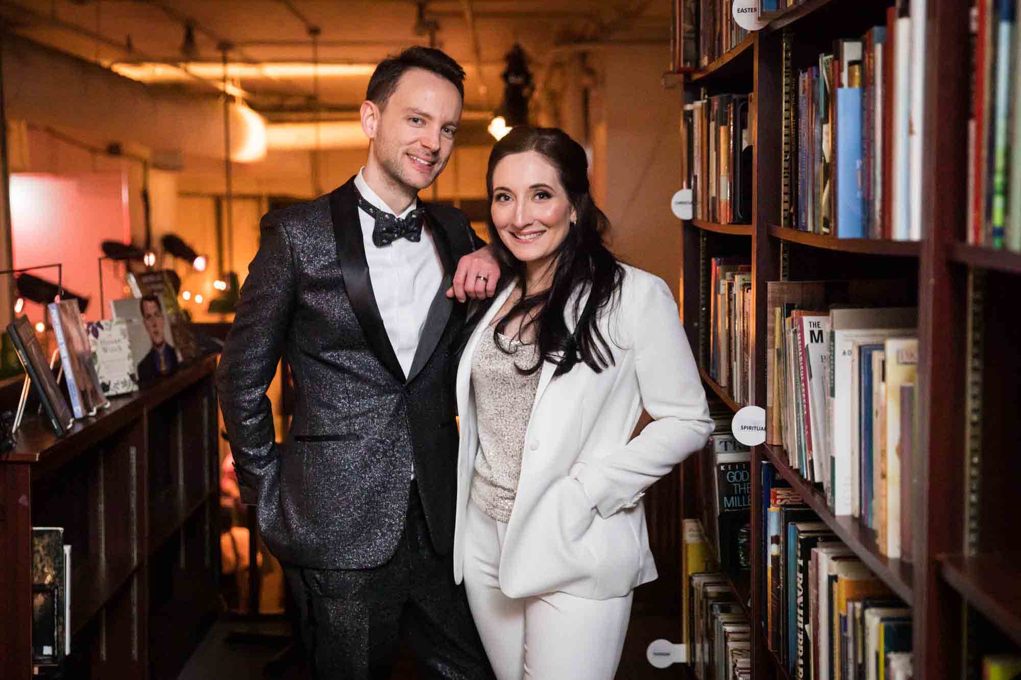 Bride and groom in front of bookcase at a Housing Works Bookstore wedding