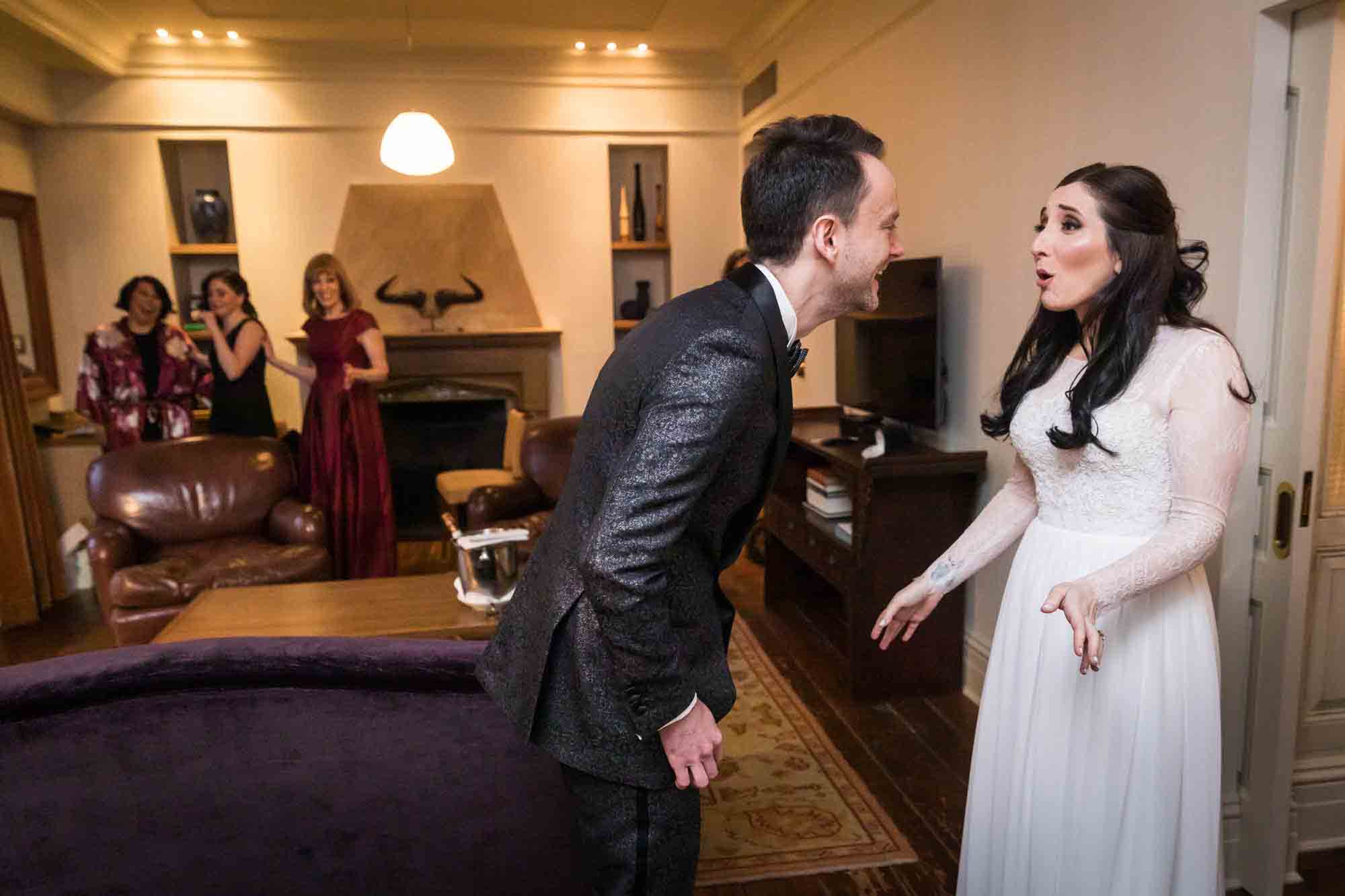 Bride and groom seeing each other during first look in hotel room