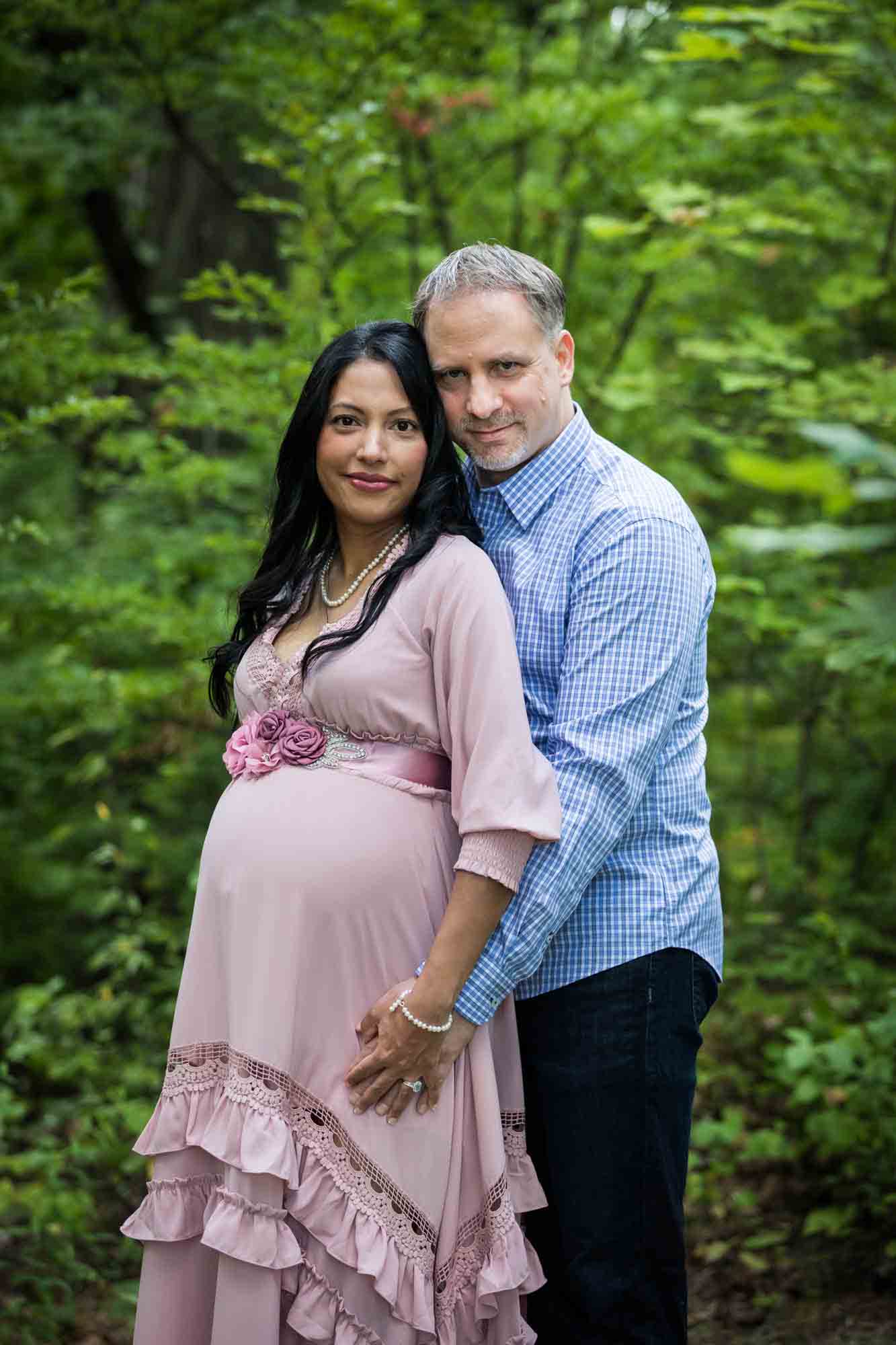 Forest Park maternity photos of a couple standing in a forest