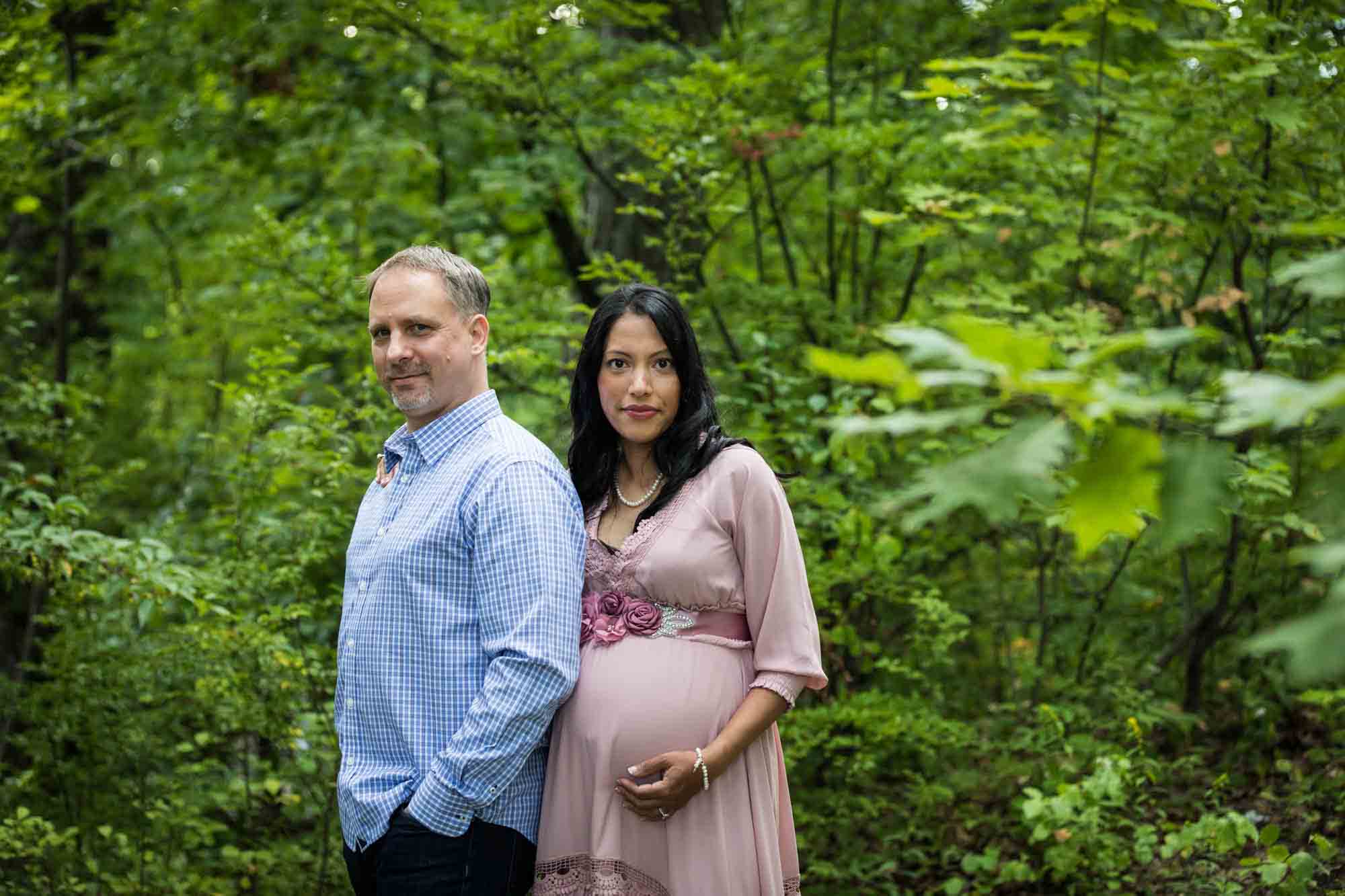 Forest Park maternity photos of a couple standing in a forest