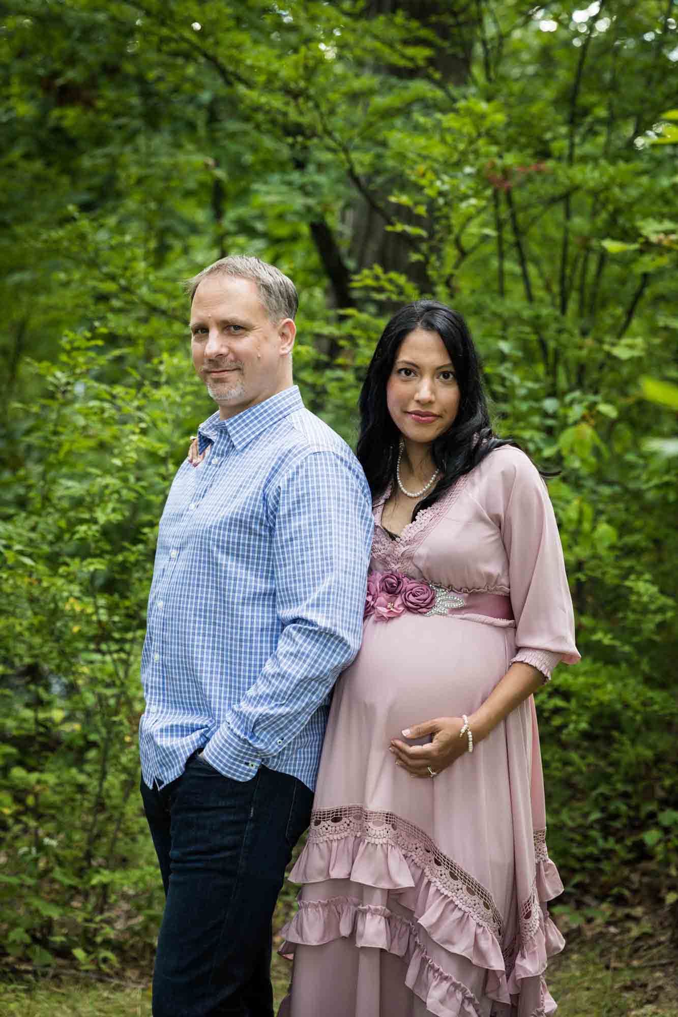 Forest Park maternity photos of a couple standing in a forest