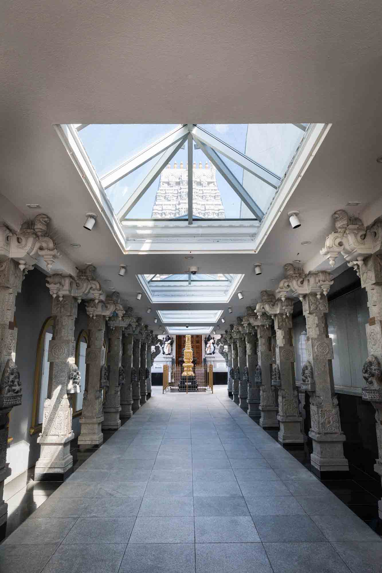 Main entrance to the Hindu Temple Society of North America with skylight and statues